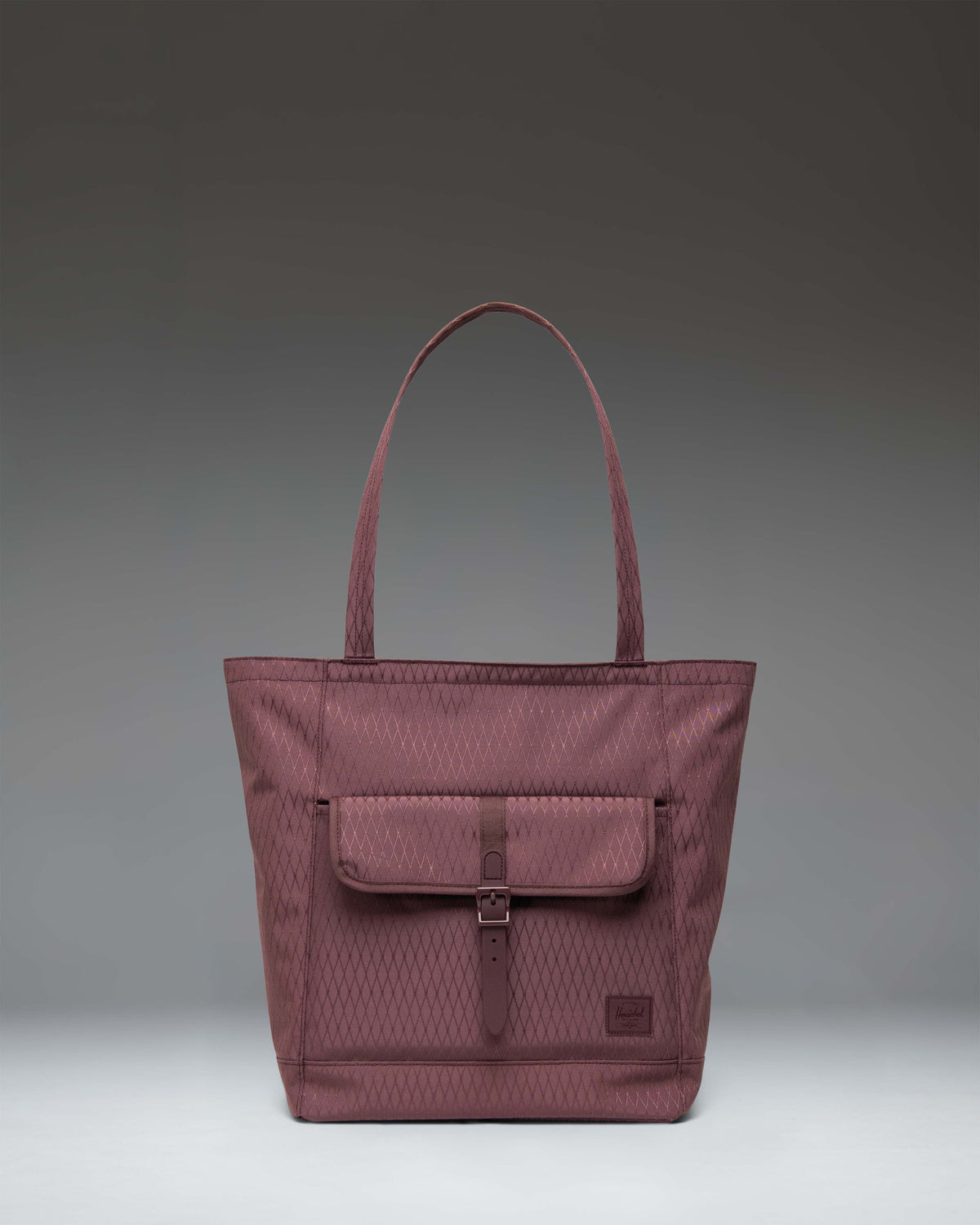 Herschel Retreat Tote in Huckleberry Diamond, featuring a dark blue-purple hue with a front storage pocket and a buckle strap closure.