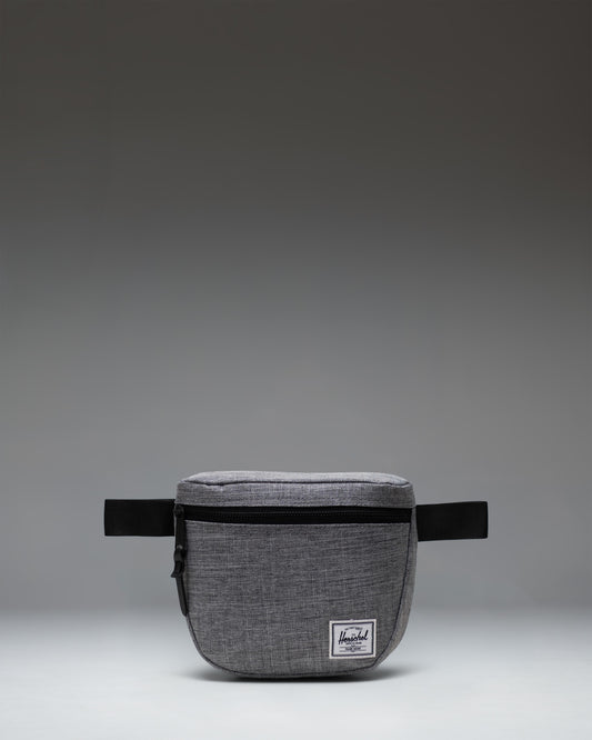 Herschel Supply Co. Settlement Hip Pack in Raven Crosshatch grey, showing the front view with zipper detail and classic woven label.