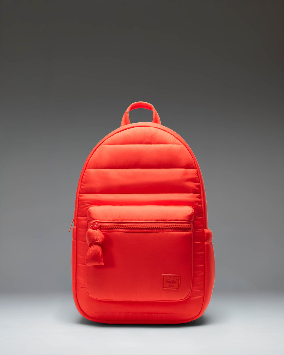 Herschel Supply Co. Settlement Backpack in Tangerine Tango, featuring a vibrant orange color, front zipper pocket, and classic woven label.