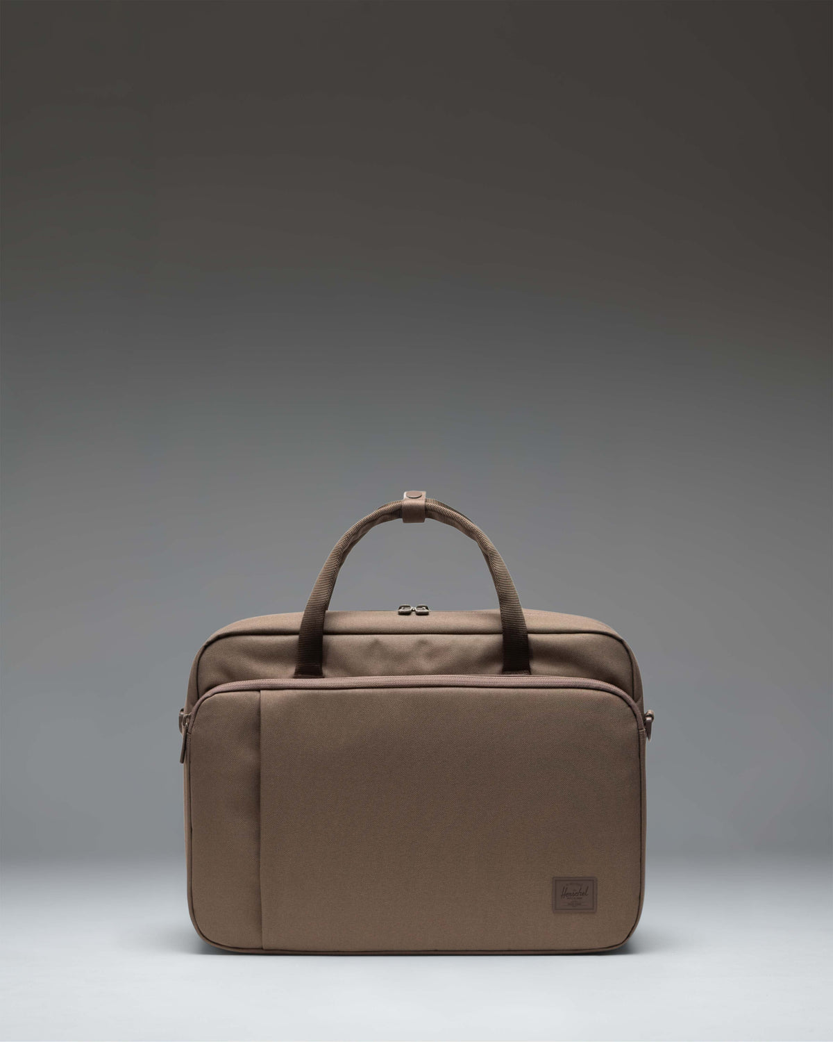 Herschel Supply Co. Gibson Messenger Tech bag in light brown, featuring dual top handles and an adjustable shoulder strap.