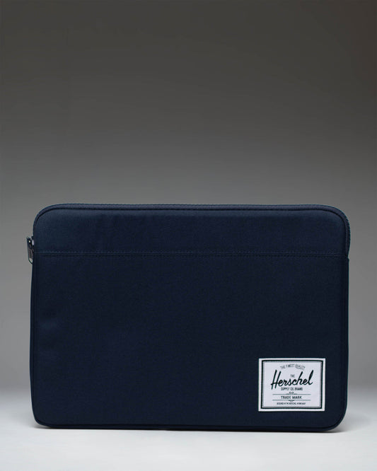 Herschel Supply Co Anchor 14 inch laptop sleeve in solid navy blue with a classic woven logo label on the bottom corner.