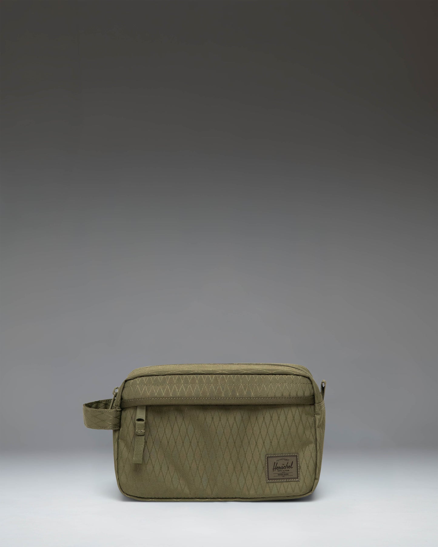 Herschel Supply Co. Chapter Travel Kit in Ivy Green Diamond with a side carrying handle and front zip pocket.