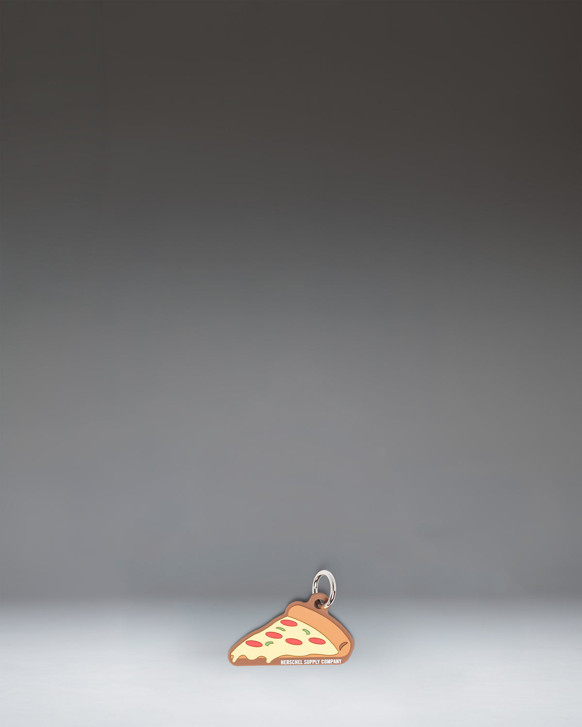 Herschel Pizza Bag Charm in Pepperoni colorway, styled like a slice of pepperoni pizza.