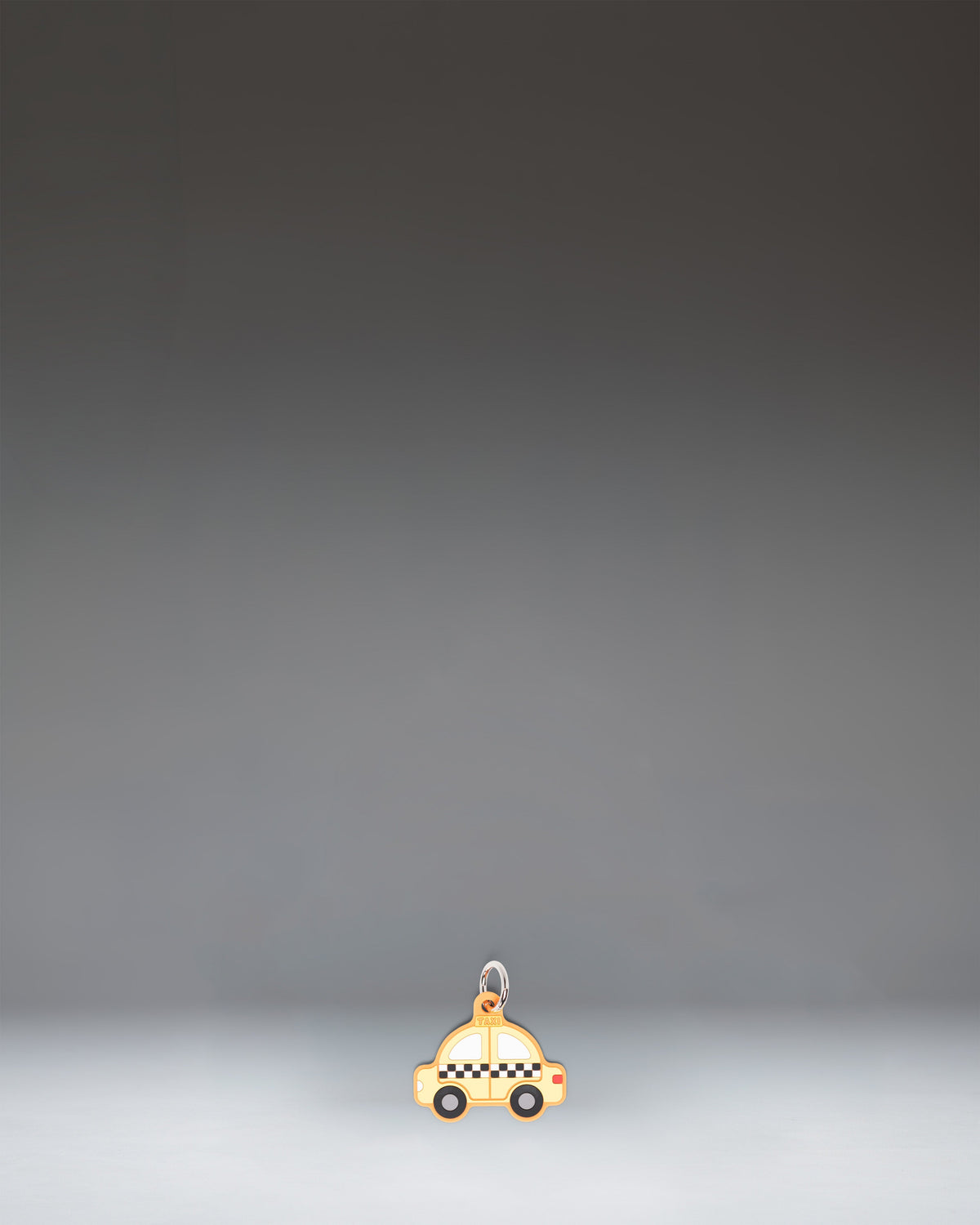 Herschel Taxi Bag Charm in Taxi, a yellow checker-cab-inspired miniature bag accessory with black and white checkered details.