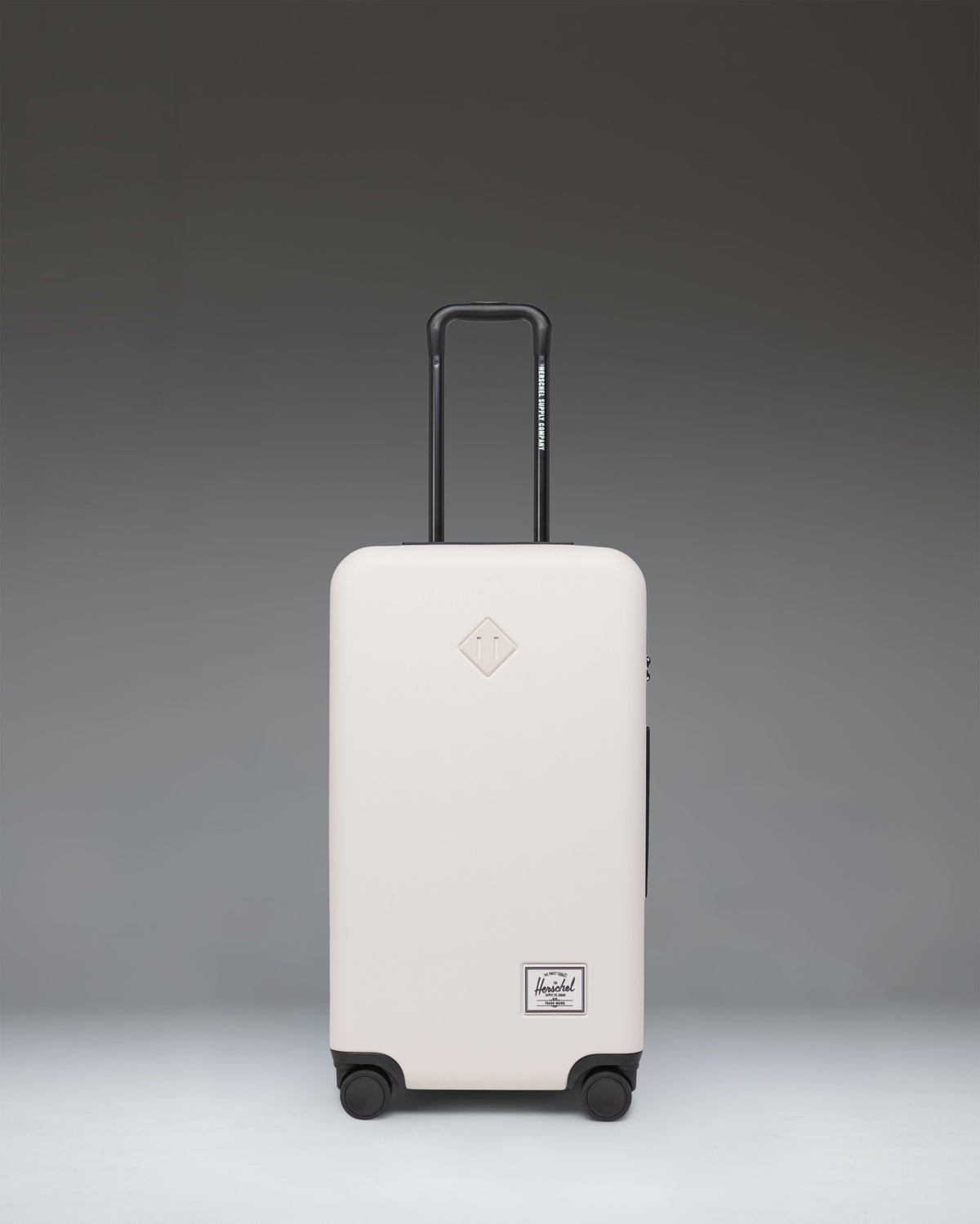 Herschel Heritage Hardshell Medium Luggage in Moonbeam, a cream-colored hard-shell suitcase.