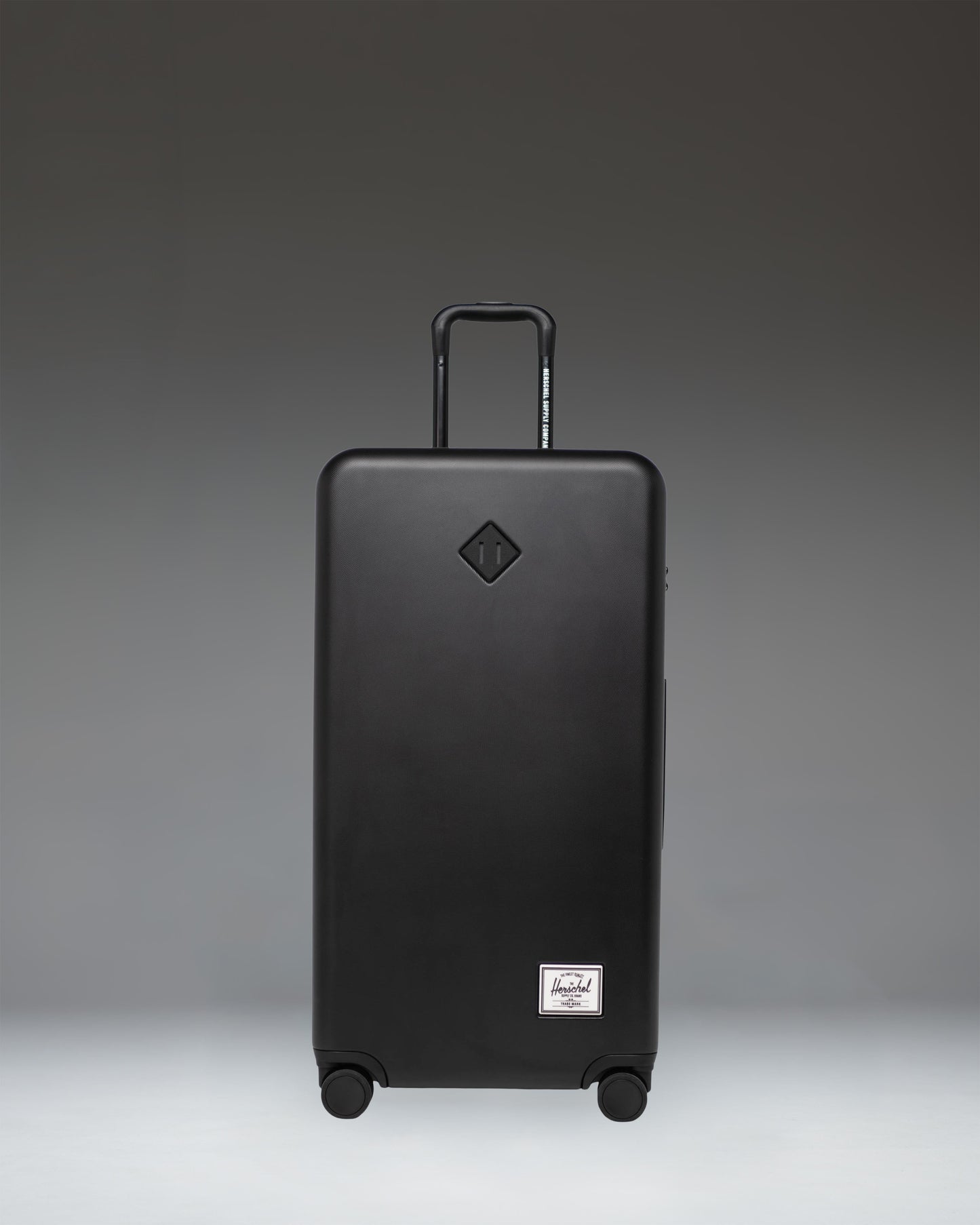 Front view of the Herschel Heritage Hardshell Large Luggage in black, showing its durable, textured exterior design.