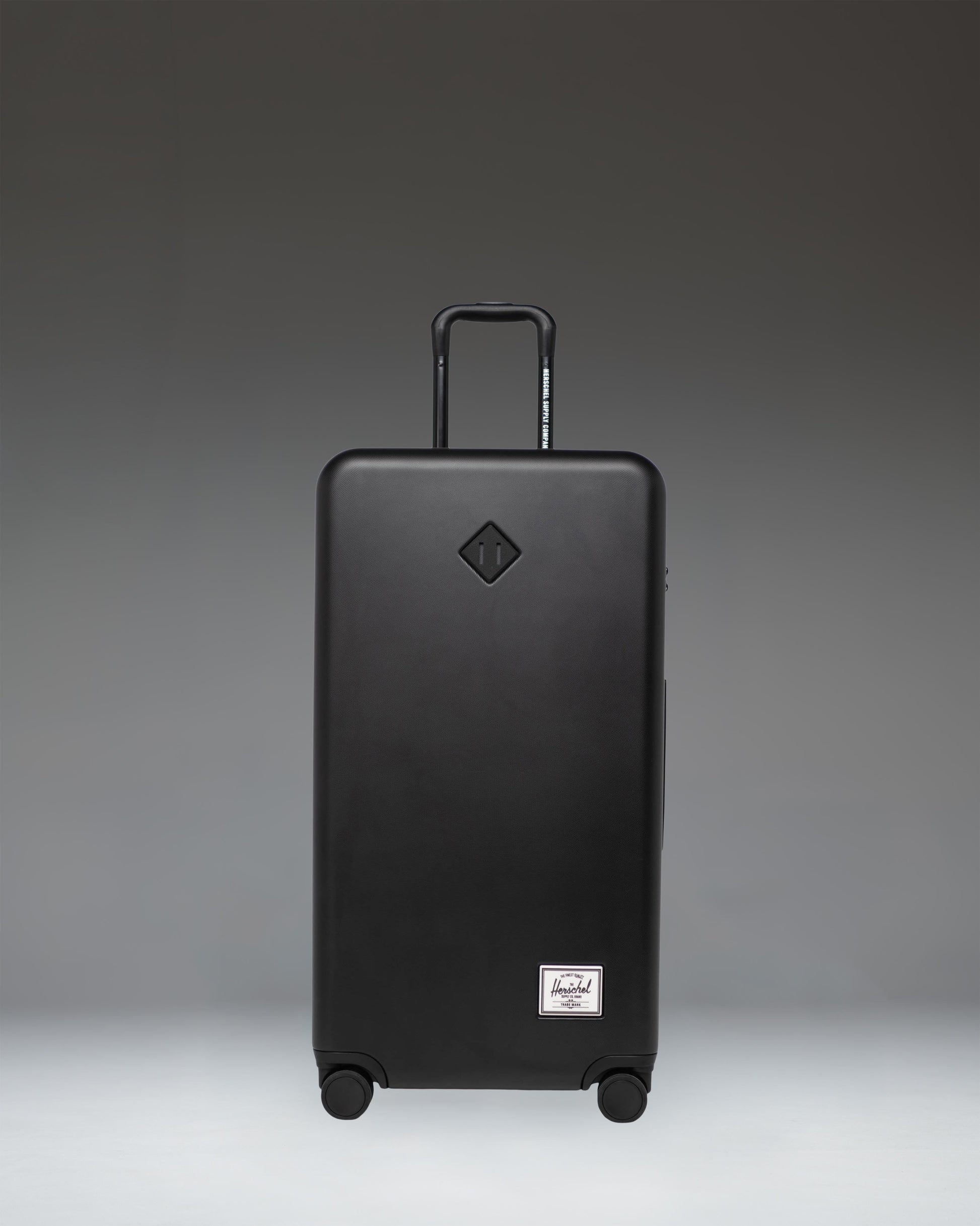 Front view of the Herschel Heritage Hardshell Large Luggage in black, showing its durable, textured exterior design.