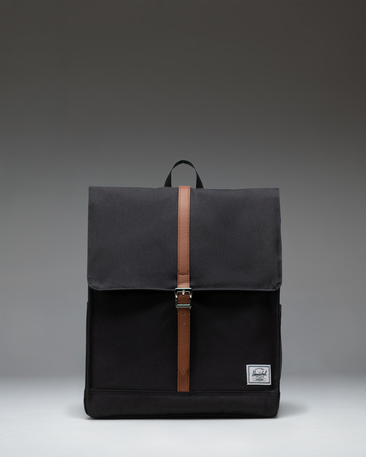 Herschel Supply Co. City Backpack in black, featuring a clean, minimalist design with a single strap closure and front storage sleeve.