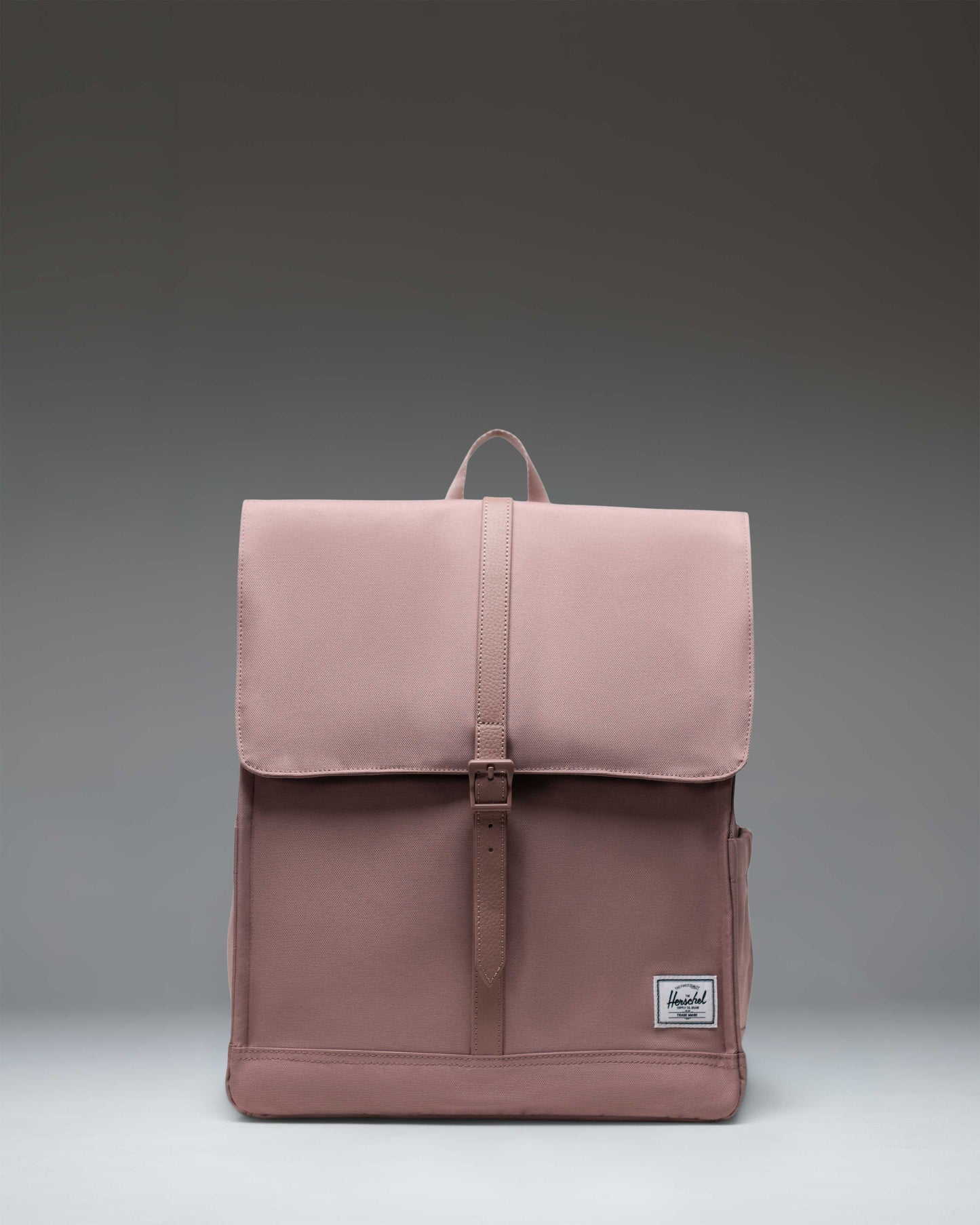 Herschel Supply Co. City Backpack in Ash Rose pink, featuring a slim design with a single strap closure and front storage pocket.