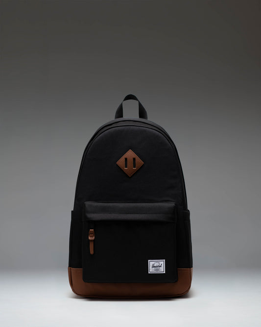 Herschel Heritage Backpack in Black with a Tan brown diamond accent and bottom panel, shown from the front on a white background.