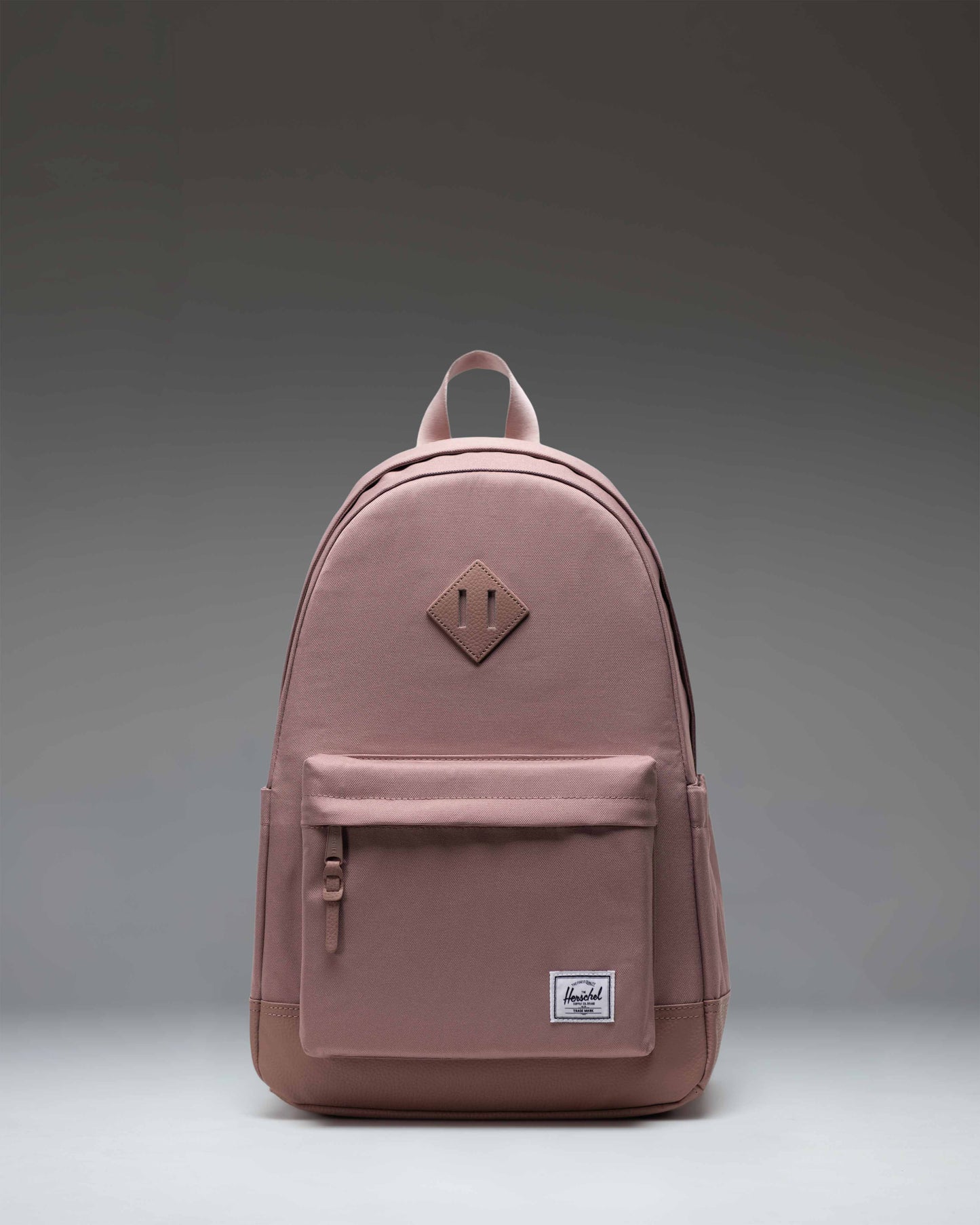 Herschel Supply Co. Heritage Backpack in Ash Rose, showcasing a classic design with a front pocket and signature diamond accent.