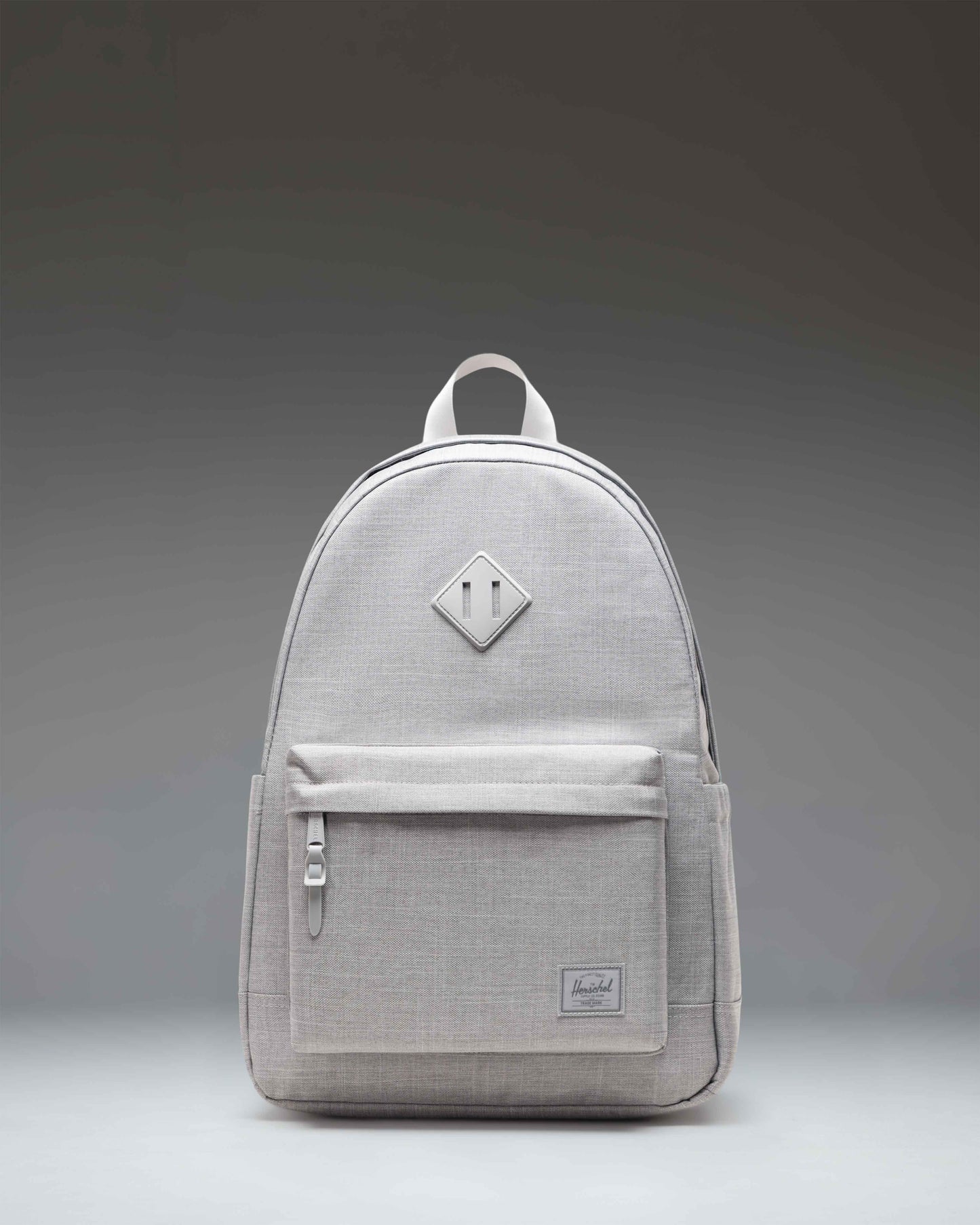 Herschel Heritage Backpack in Grey Crosshatch showing the front view with a brown diamond accent and a zippered front pocket.