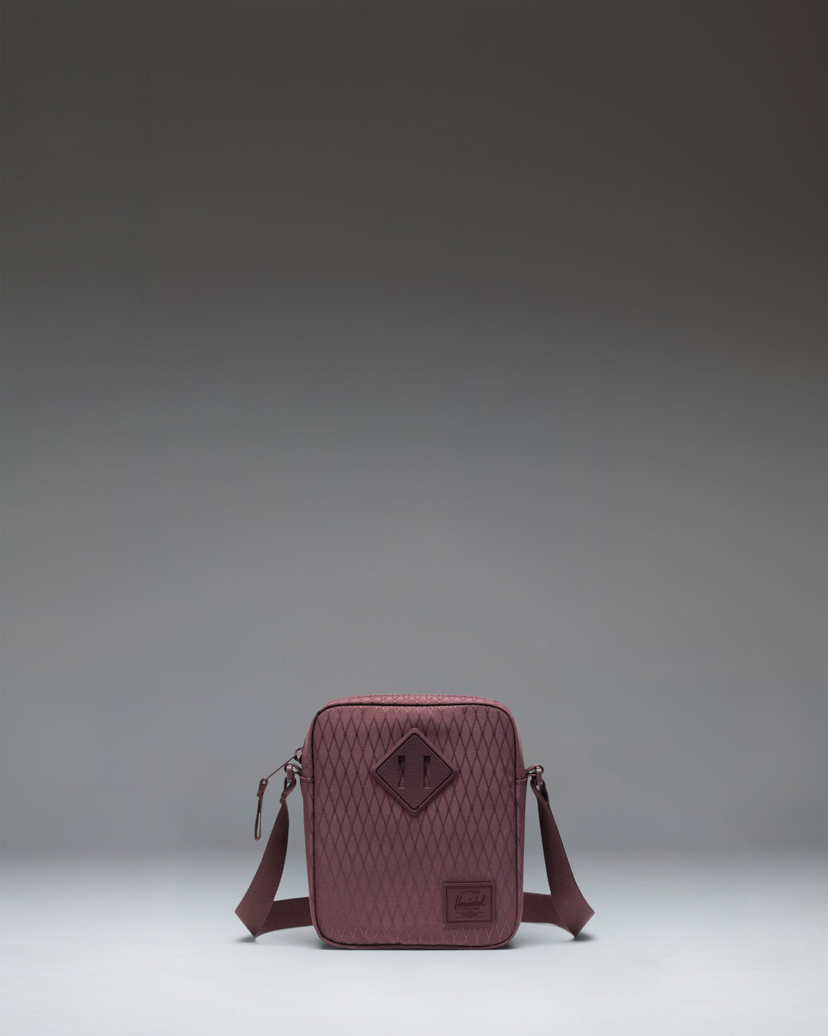 Herschel Heritage Crossbody bag in Huckleberry Diamond, featuring a dark blue patterned fabric with a tan diamond patch.