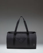 Herschel Heritage Duffle bag in Black Tonal, showing the front profile with a clean design, dual carrying handles, and a signature woven label.