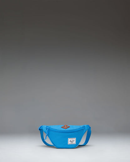 Herschel Heritage Hip Pack Little Herschel in French Blue, showing a compact hip pack with a front zippered pocket and adjustable strap.