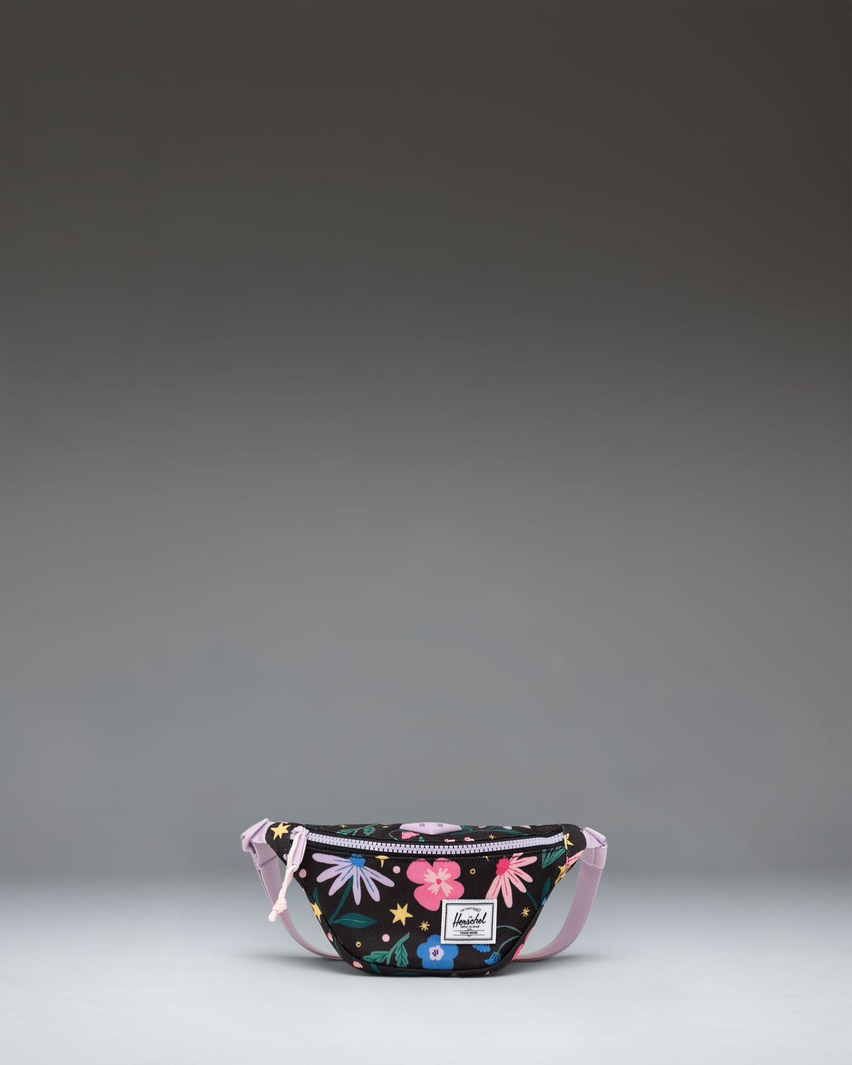 Little Herschel Heritage Hip Pack in Enchanted Garden, a floral-patterned waist bag featuring a front pocket and adjustable strap.