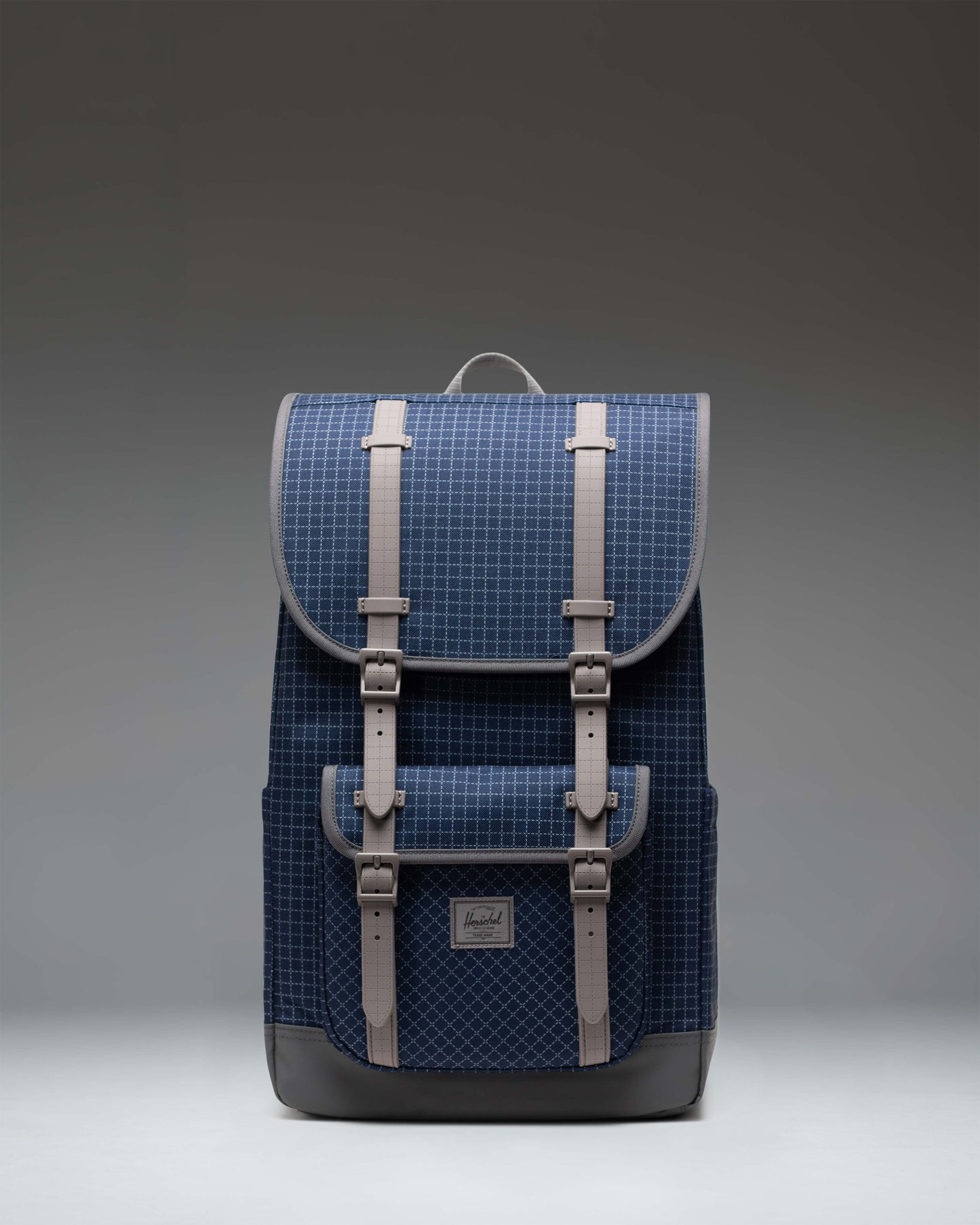 Herschel Little America Backpack in Grid Naval Academy and Magnet navy blue with adjustable straps and magnetic buckle closures.