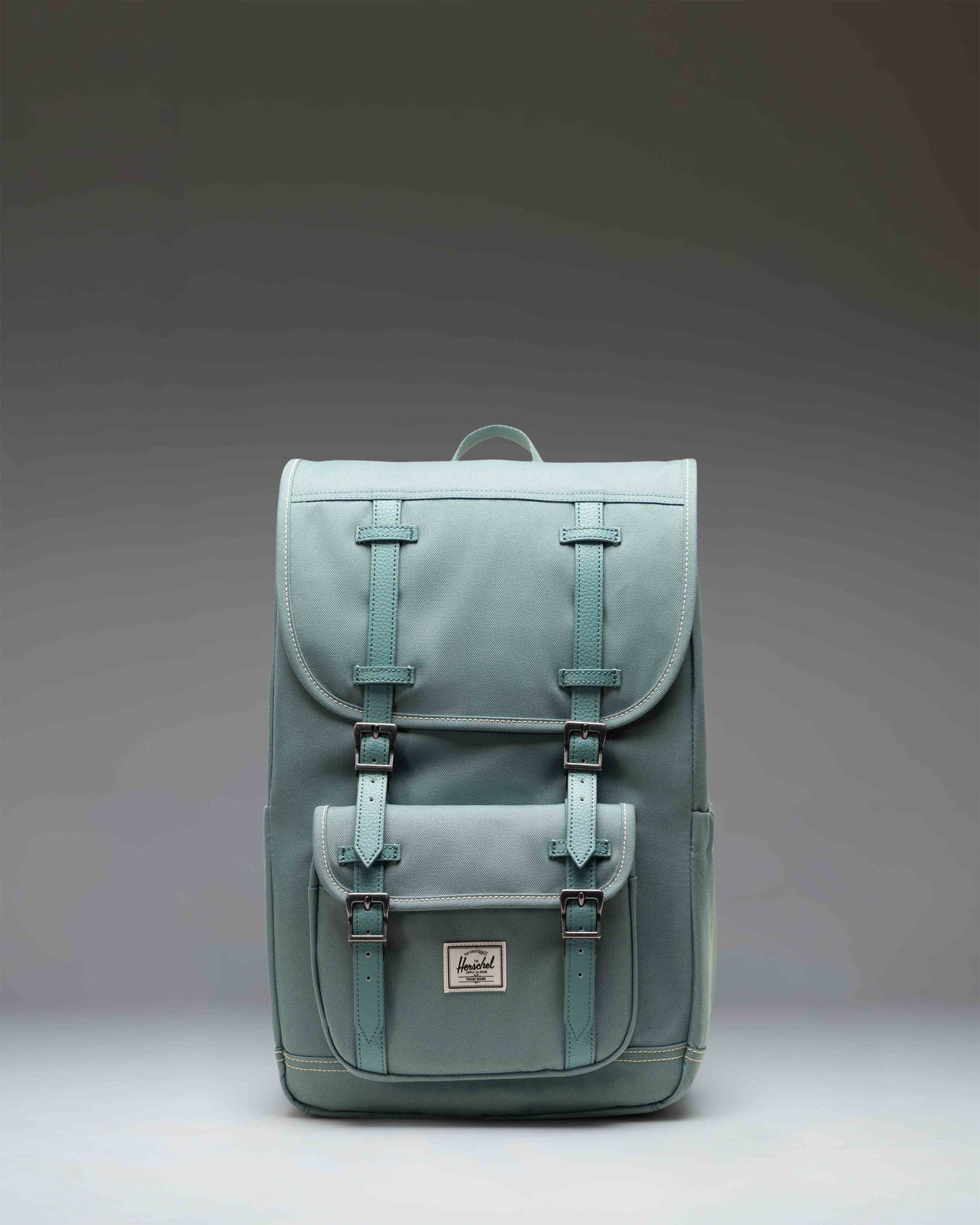 Herschel Little America Mid Backpack in olive green with tan magnetic straps and a front zipper pocket.