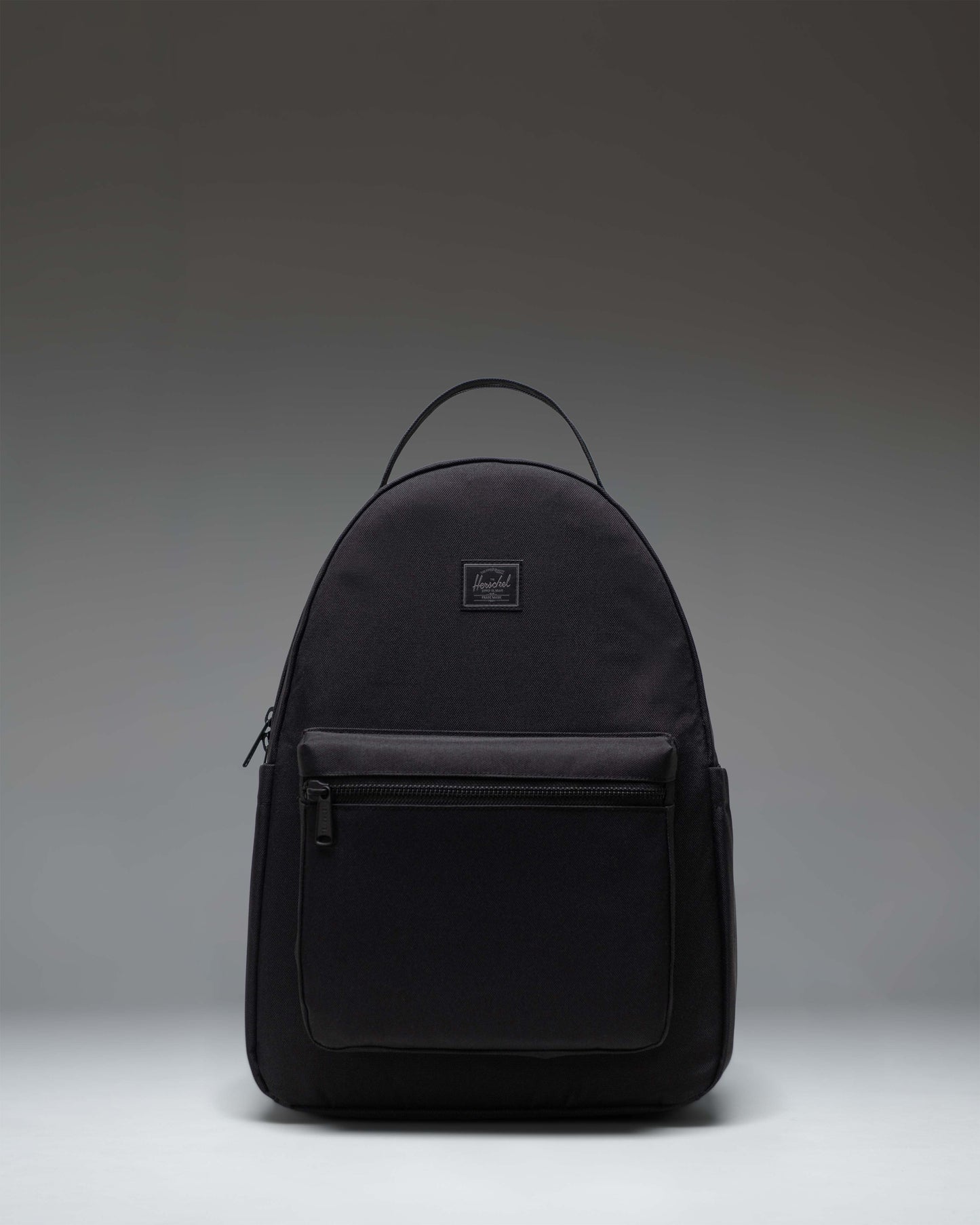 Herschel Nova Backpack in Black Tonal, showing the front view with dual top carrying handles and a front storage pocket.