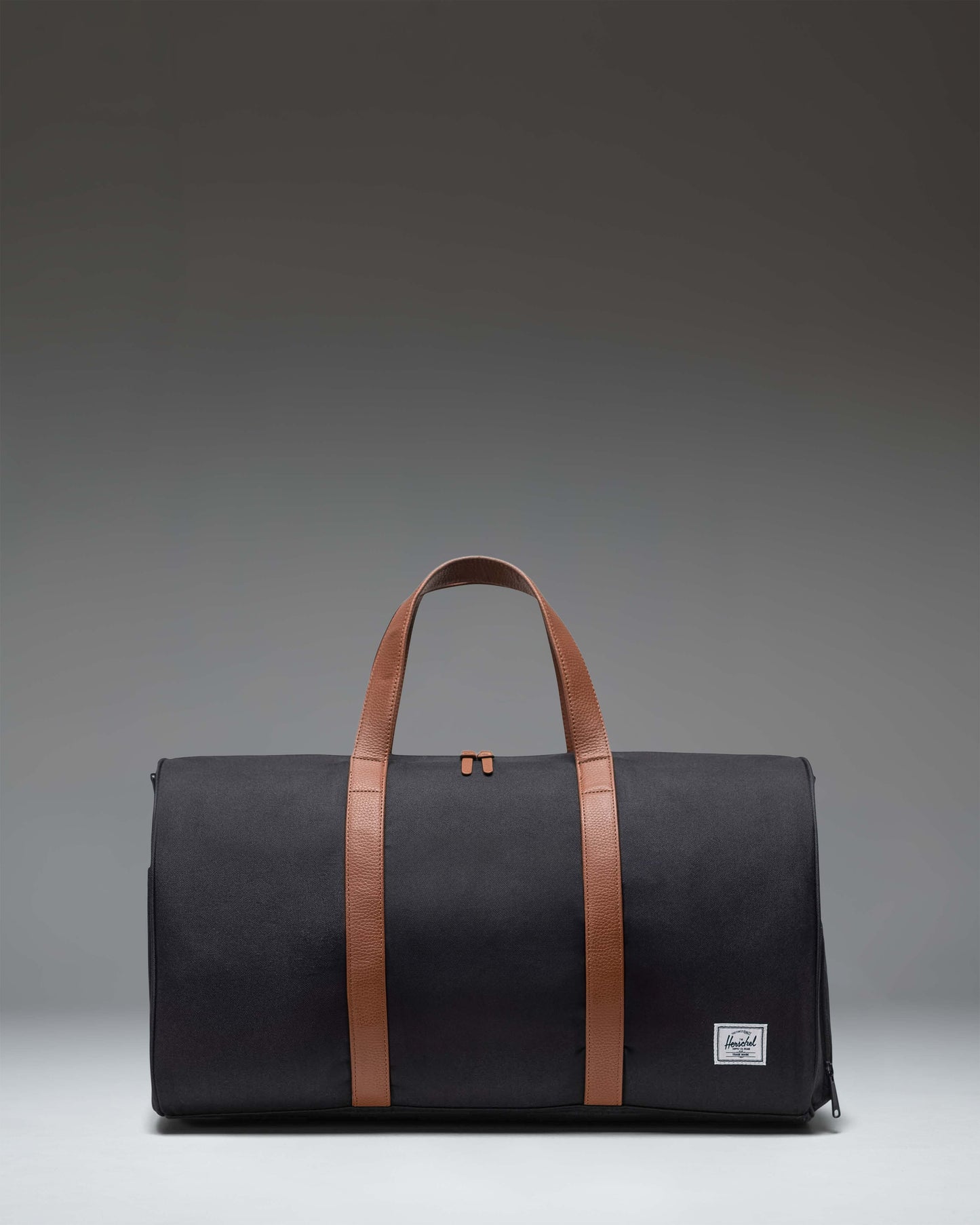 Herschel Novel Duffle bag in classic black, showing a side view highlighting its clean design and signature shoe compartment.