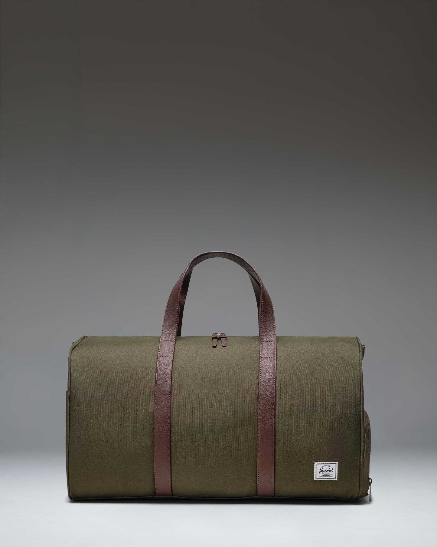 Herschel Novel Duffle bag in Ivy Green, featuring a classic duffle design with top handles, a shoulder strap, and a signature shoe compartment.