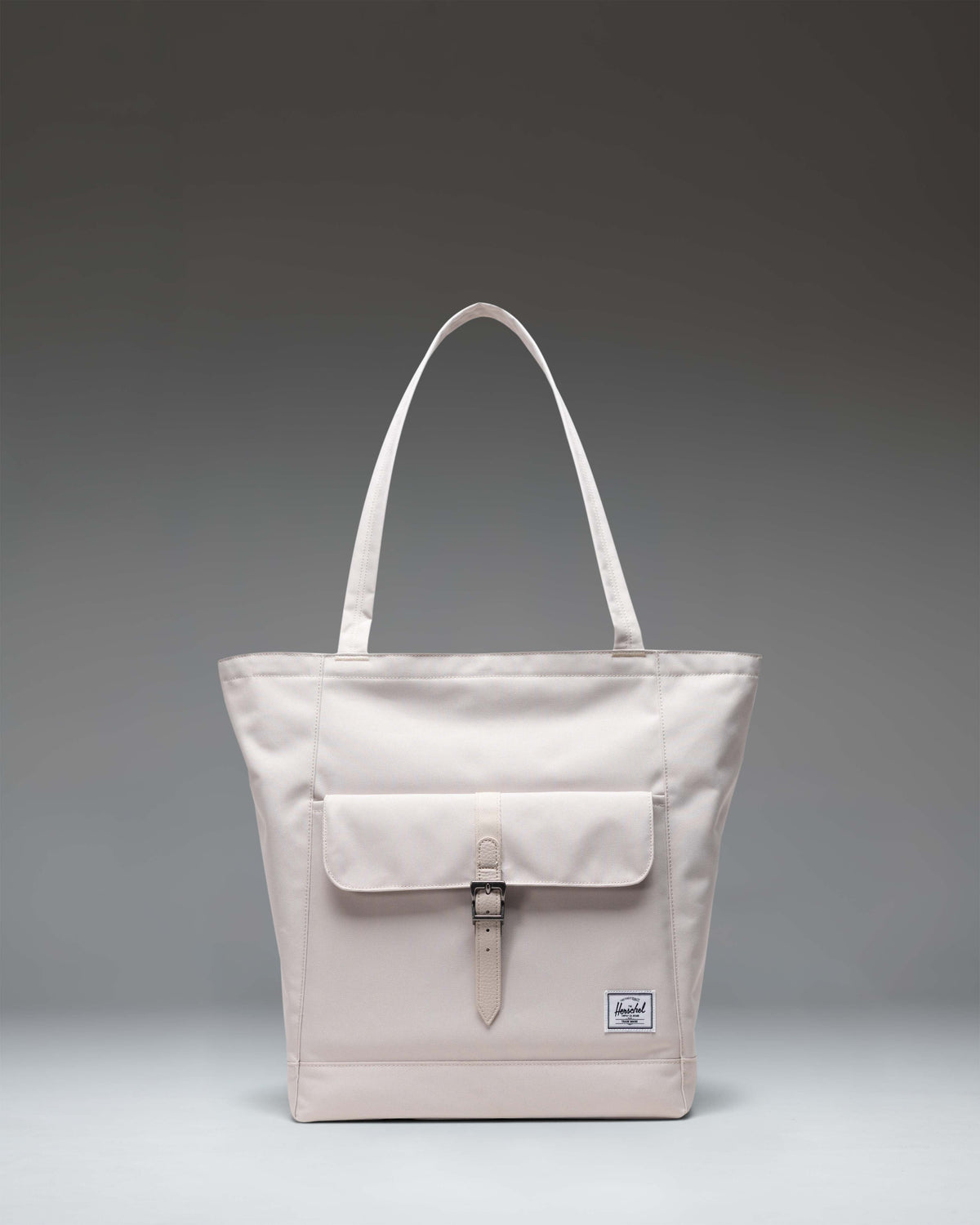 Herschel Retreat Tote in Moonbeam colorway, showing the clean front design with a subtle logo patch and durable carry handles.