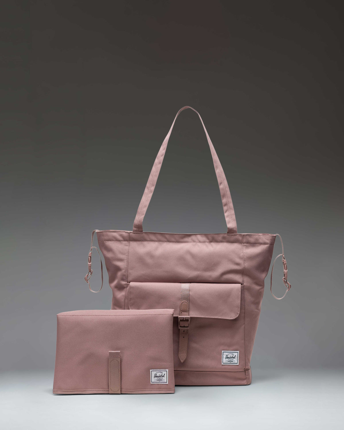 Herschel Retreat Tote Diaper Bag in Ash Rose pink showing the front view with top handles, front storage sleeve, and classic woven label.