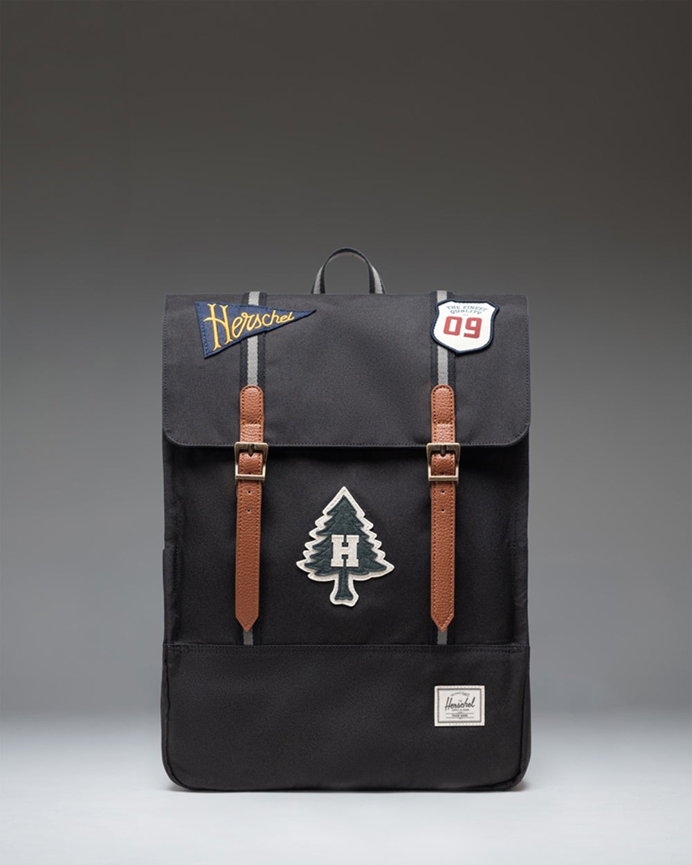Herschel Survey Backpack in Patches Black featuring a clean rectangular design with dual straps and a subtle embroidered patch pattern.