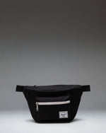 Black Herschel Supply Co Pop Quiz Hip Pack with a front zipper pocket, waterproof zipper detail, and an adjustable strap with a buckle.