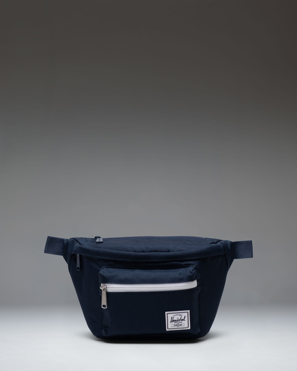 Herschel Supply Co. Pop Quiz Hip Pack in navy blue, showcasing its clean design, front pocket, and adjustable strap.