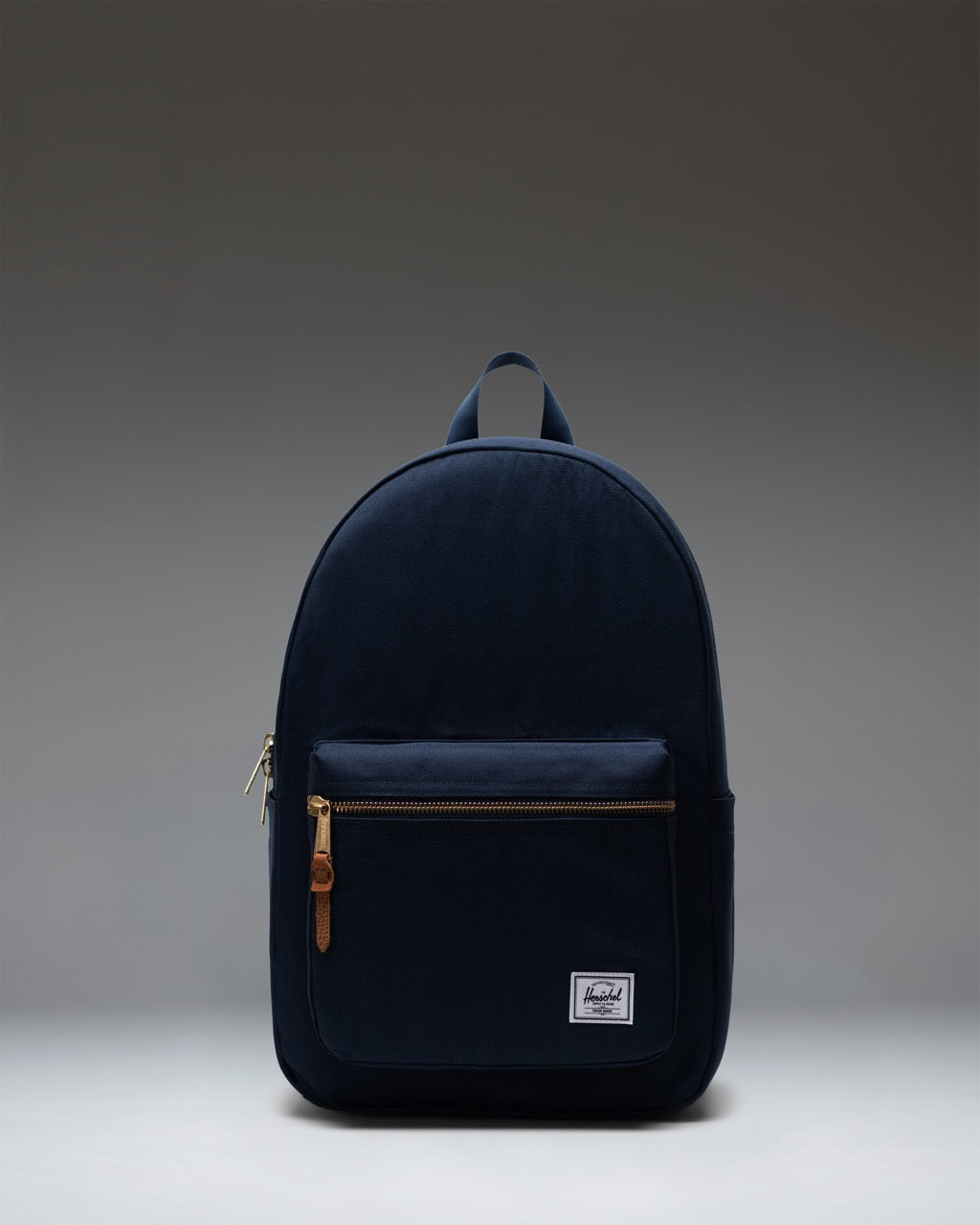 Herschel Supply Co. Settlement Backpack in navy blue, front view showing zippered pocket and classic woven label.