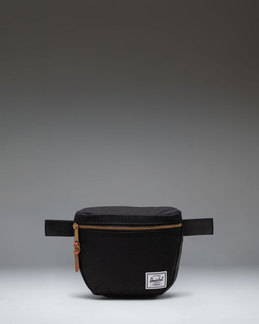 Herschel Supply Co. Settlement Hip Pack in black shown from the front, highlighting its clean design and classic woven label.