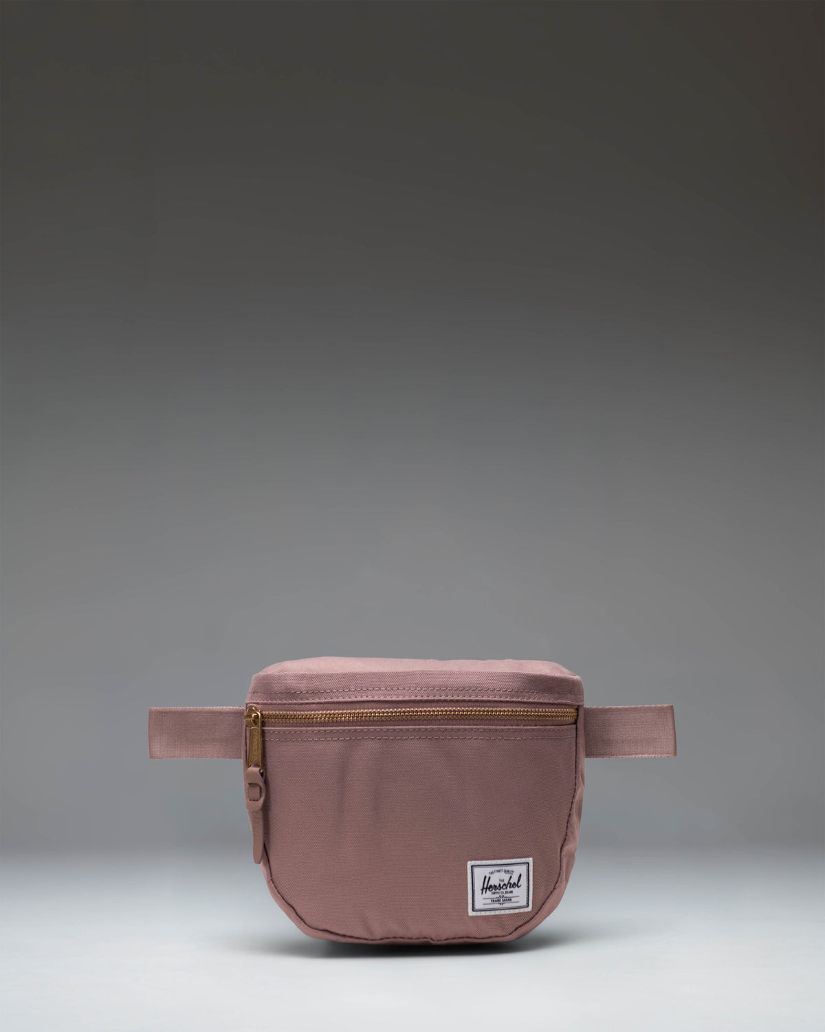 Herschel Supply Co. Settlement Hip Pack in Ash Rose pink, showing the front zippered pocket and adjustable strap.
