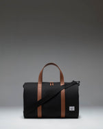 Herschel Novel Carry On Duffle in black, showing the classic side profile with the signature shoe compartment zipper.