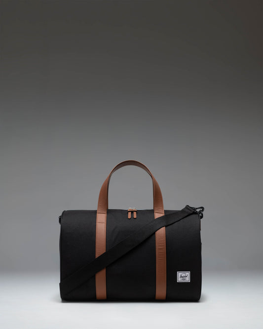 Herschel Novel Carry On Duffle in black, showing the classic side profile with the signature shoe compartment zipper.