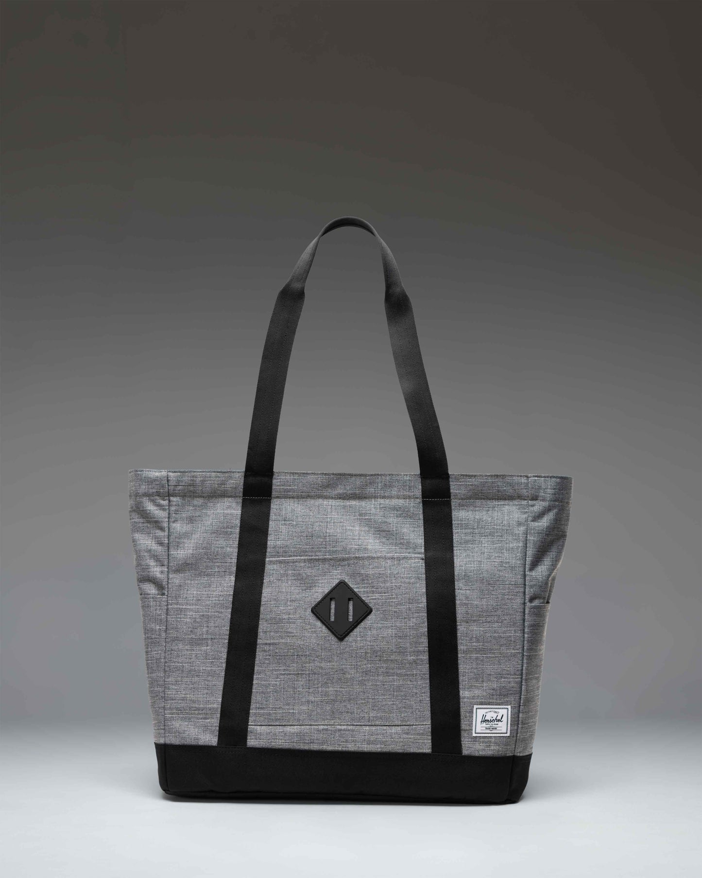 Herschel Heritage Tote bag in Raven Crosshatch grey, featuring dual carry handles and a front storage sleeve.
