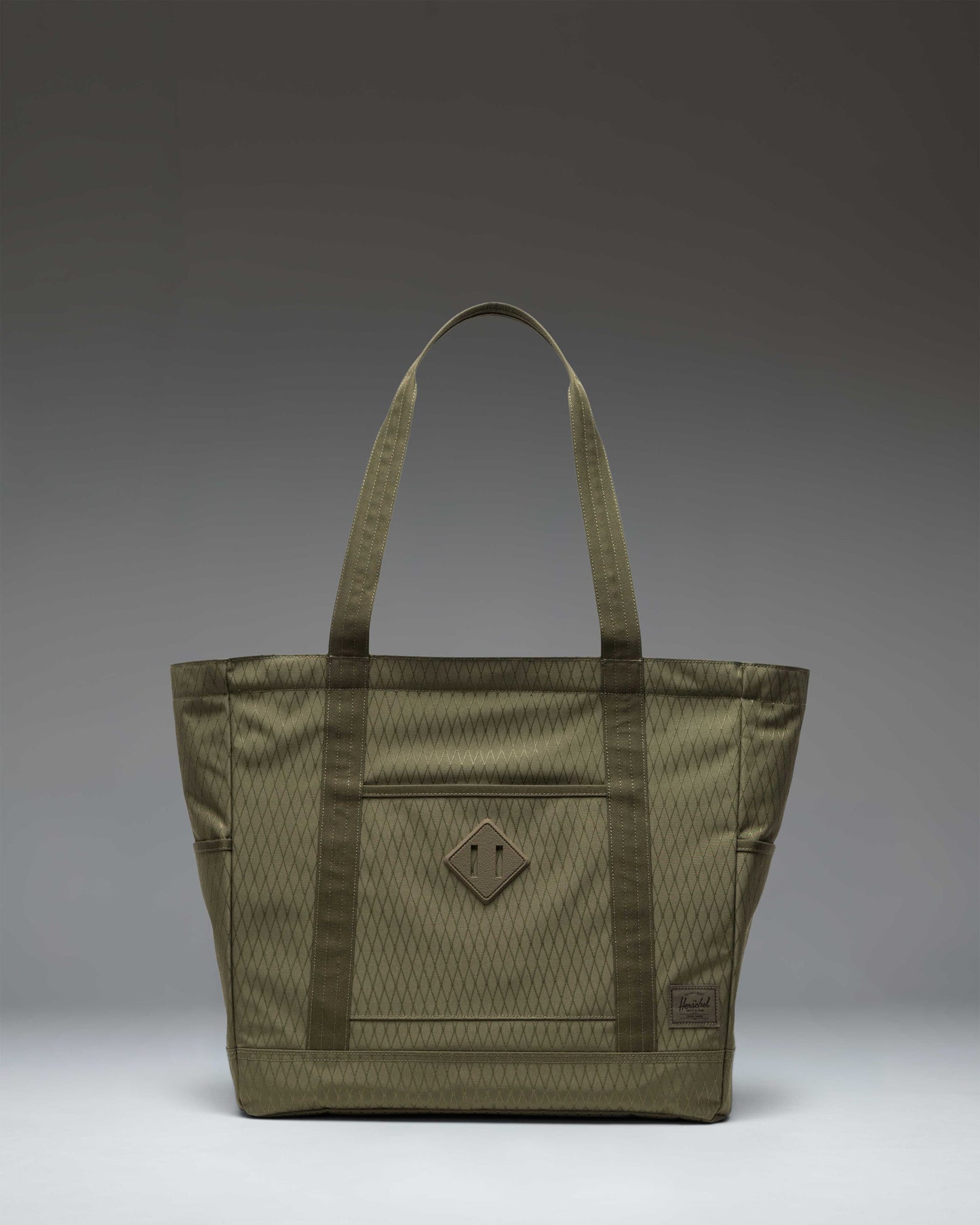 Herschel Heritage Tote in Ivy Green Diamond, featuring a classic design with dual top handles and a signature woven label on the front.