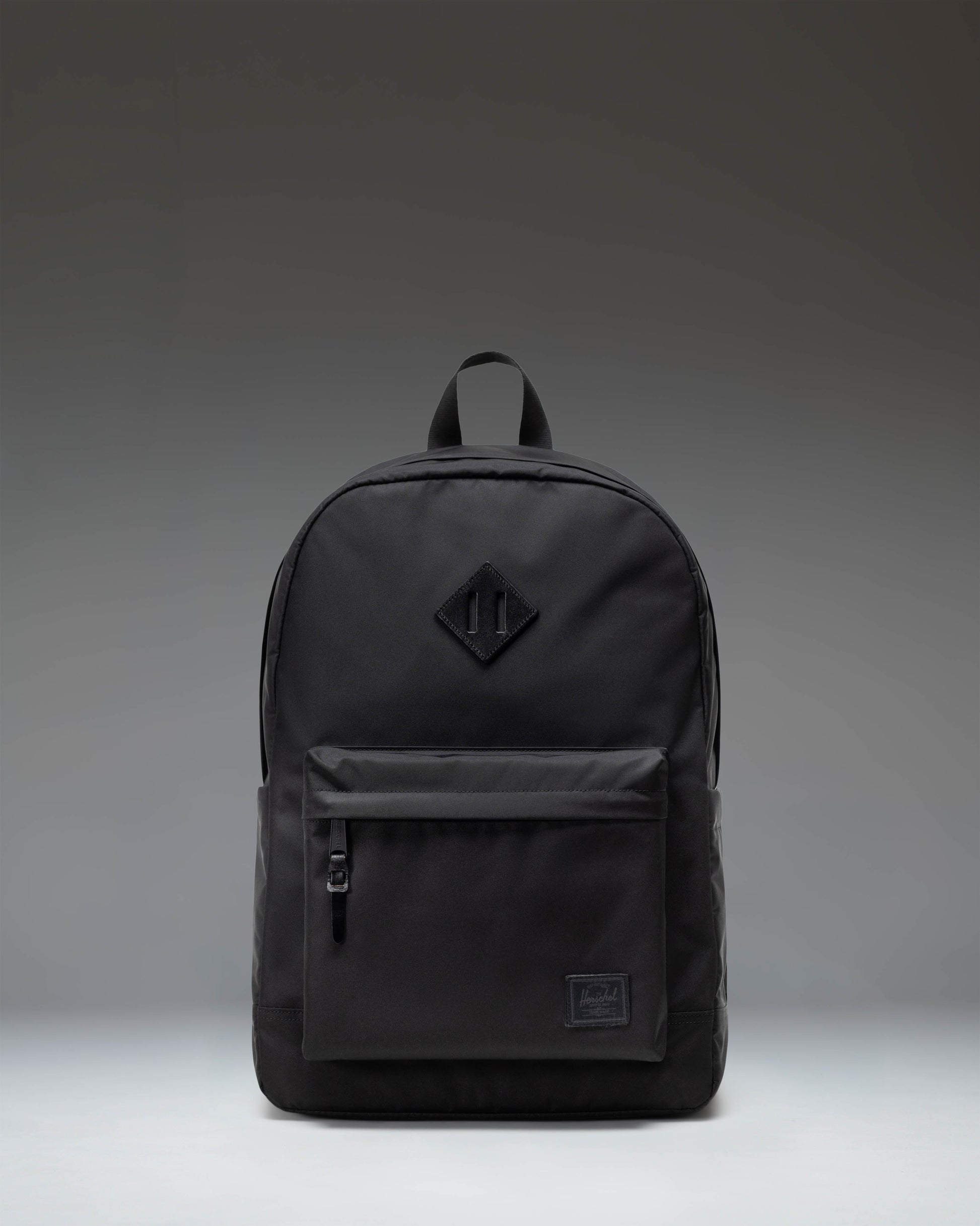 Herschel Heritage Backpack in Black featuring a classic design with a front storage pocket and signature woven label.