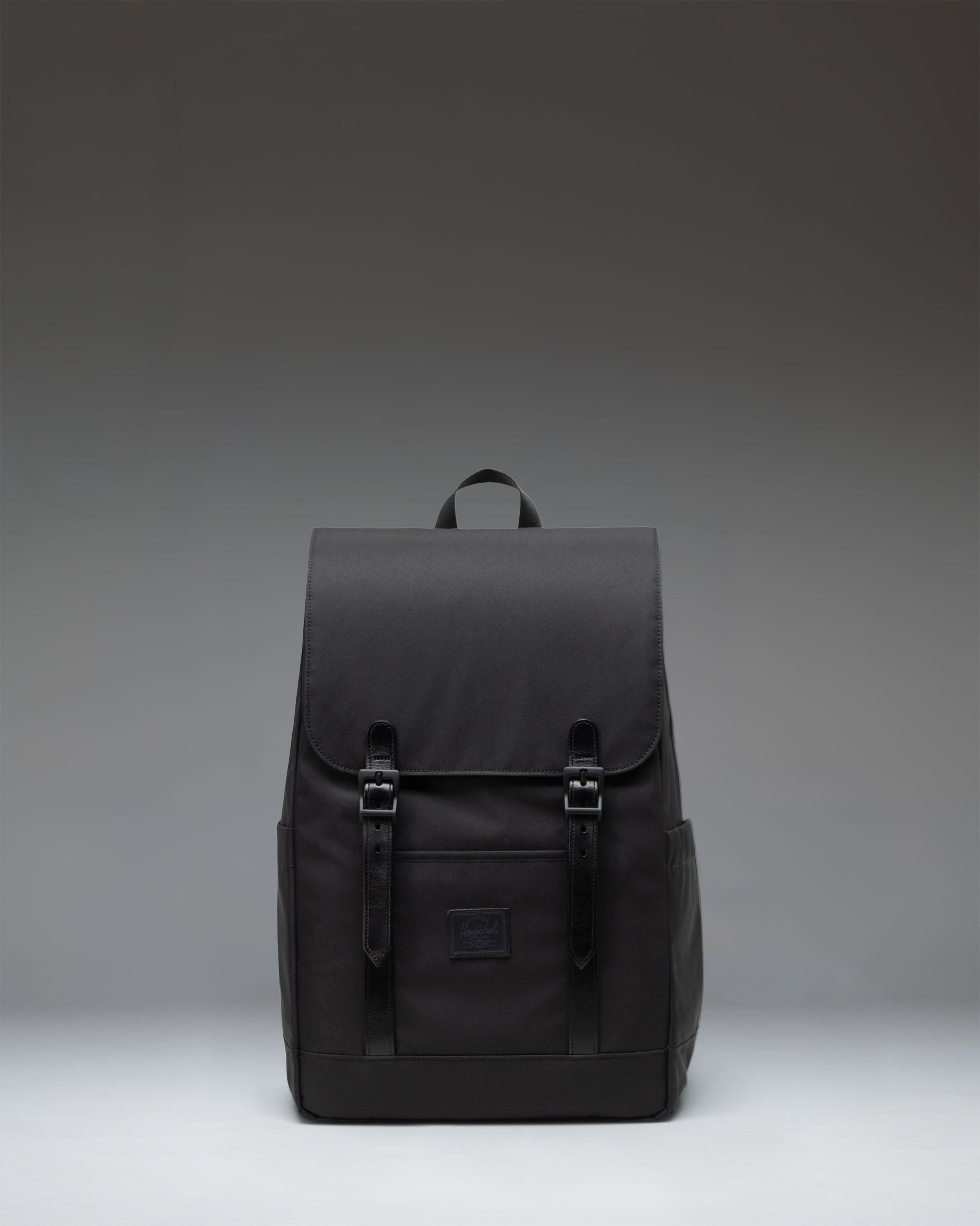 Herschel Supply Co. Retreat Small Backpack in Black showing the front view with signature strap closures.