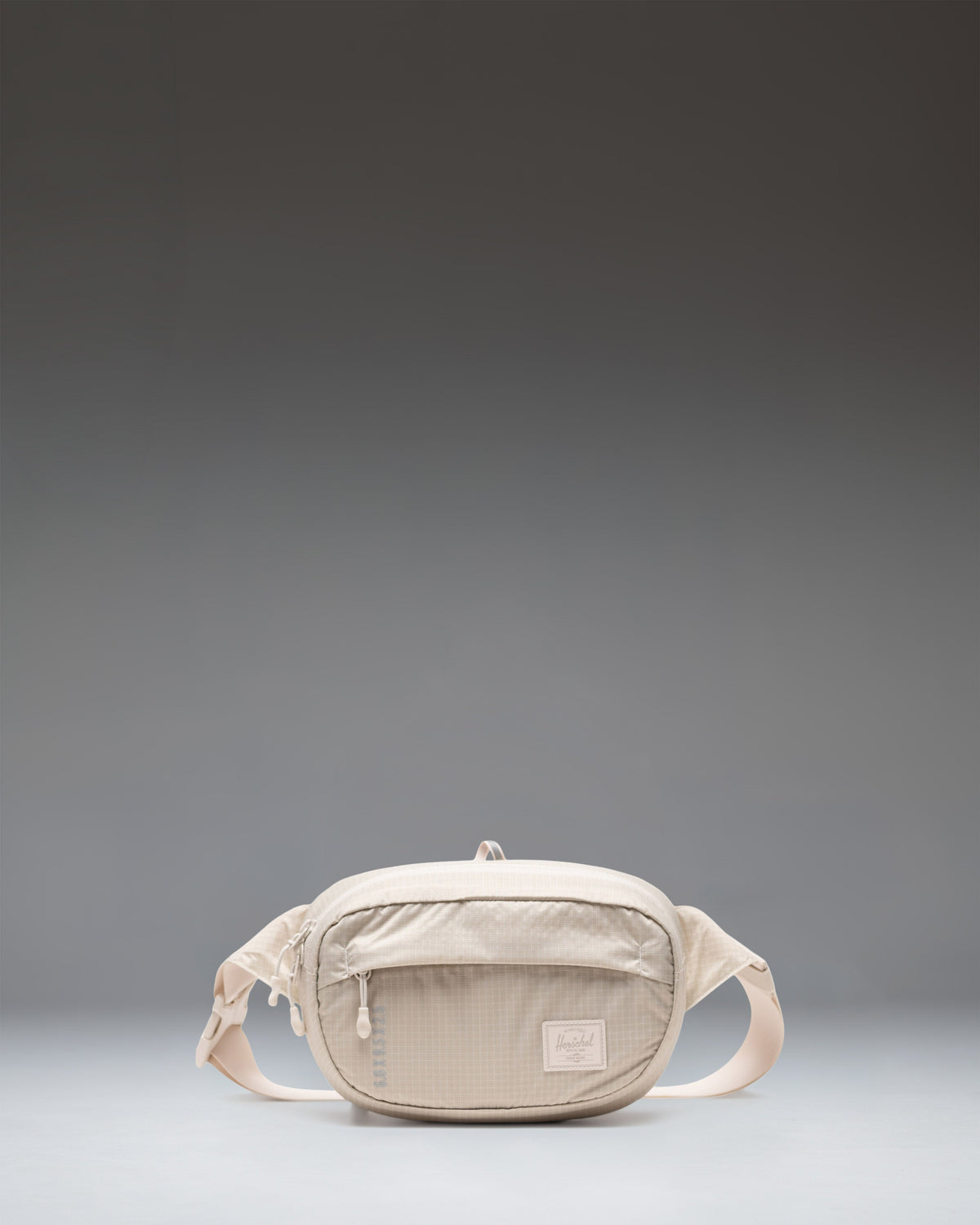 Herschel Supply Co. Ultralight Hip Pack 2L in Moonbeam beige colorway, showing the front view with zipper and adjustable strap.