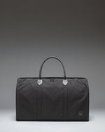 Herschel Novel Duffle bag in black, showing the clean classic design, durable handles, and signature shoe compartment.