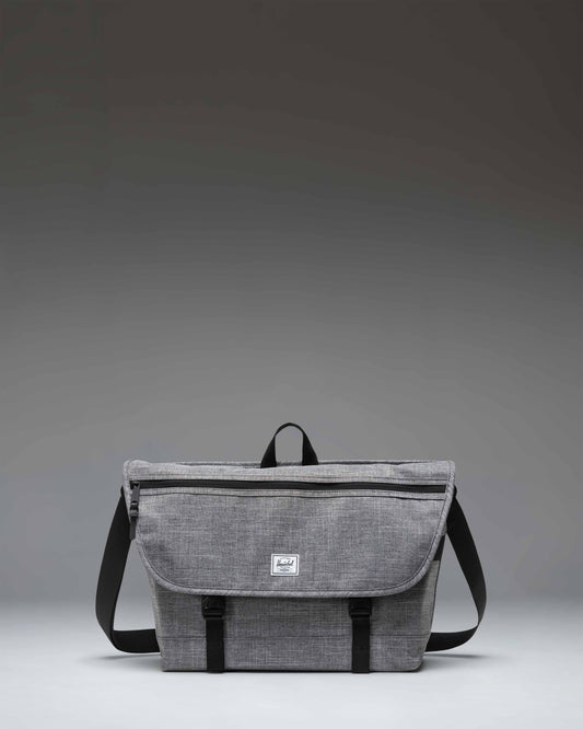 Herschel Supply Co. Cove Messenger bag in Raven Crosshatch grey, showing the front flap, buckle closure, and shoulder strap.