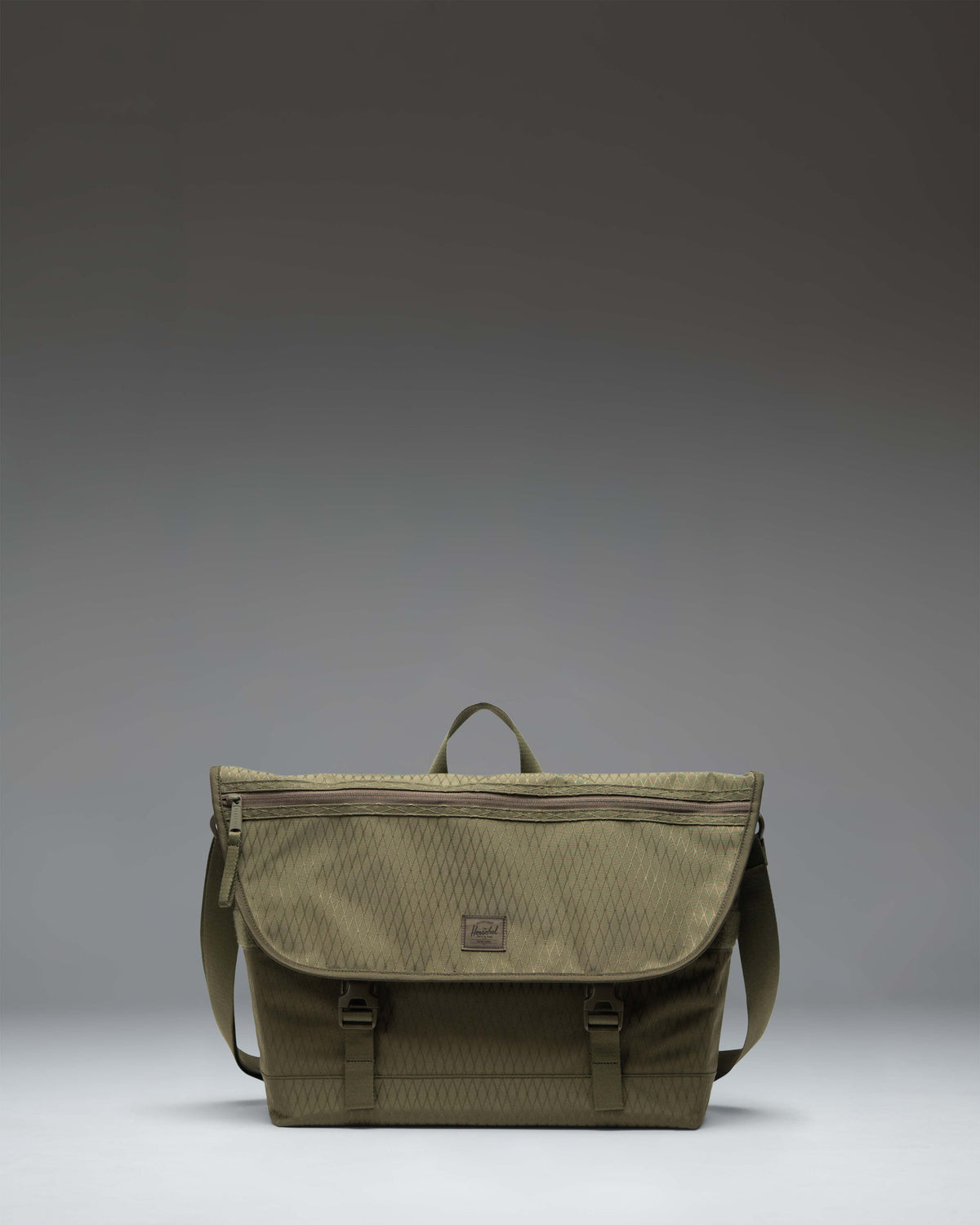 Herschel Cove Messenger bag in Ivy Green Diamond, shown from the front highlighting its textured pattern and clean design.