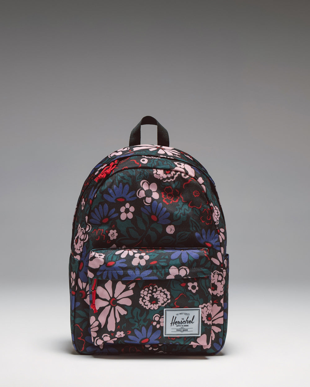 Herschel Classic Backpack in Moody Bloom, featuring a dark floral pattern with a front storage pocket.