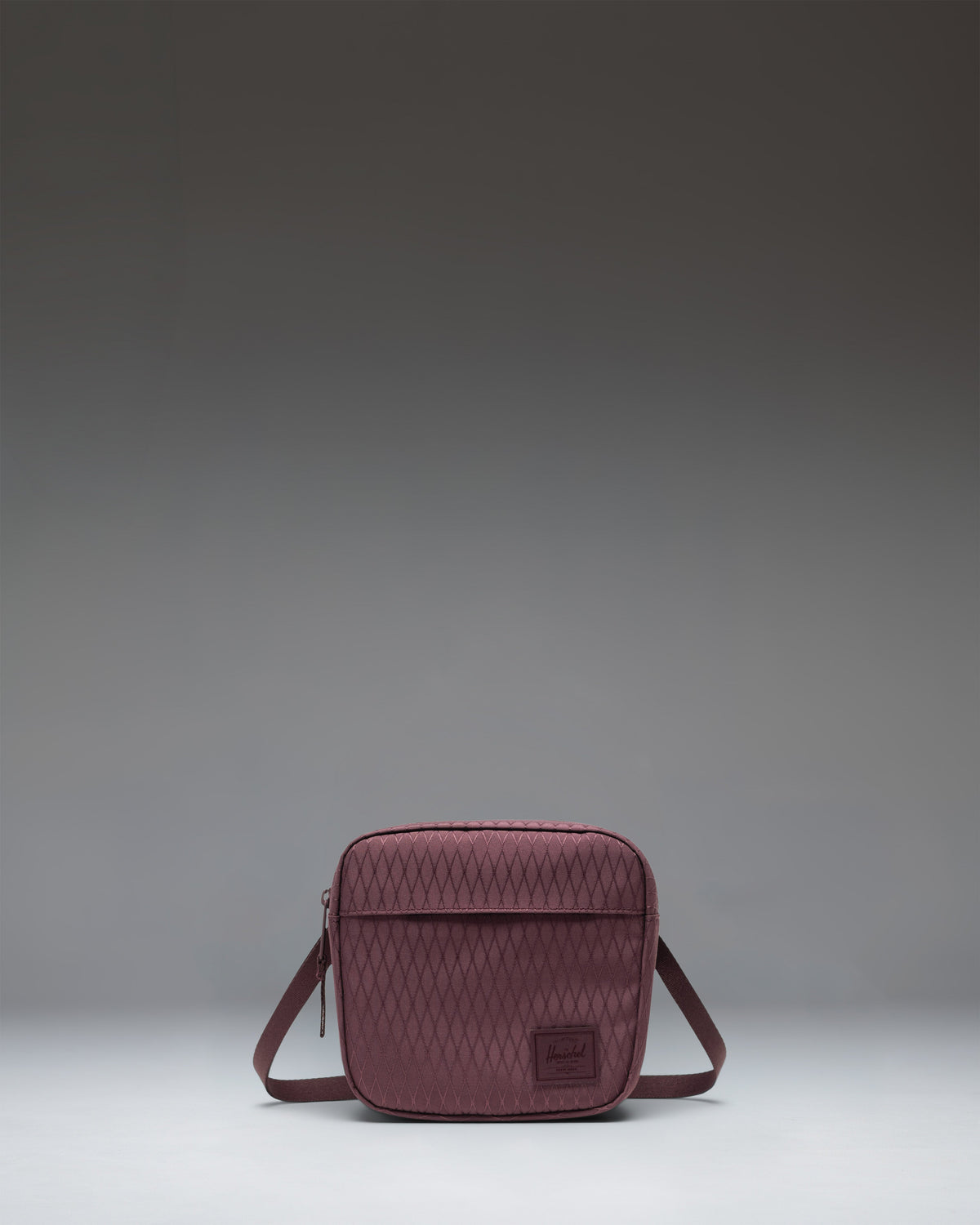 Herschel Classic Crossbody bag in Huckleberry Diamond, featuring a dark purple quilted fabric with a black adjustable strap and brand logo.