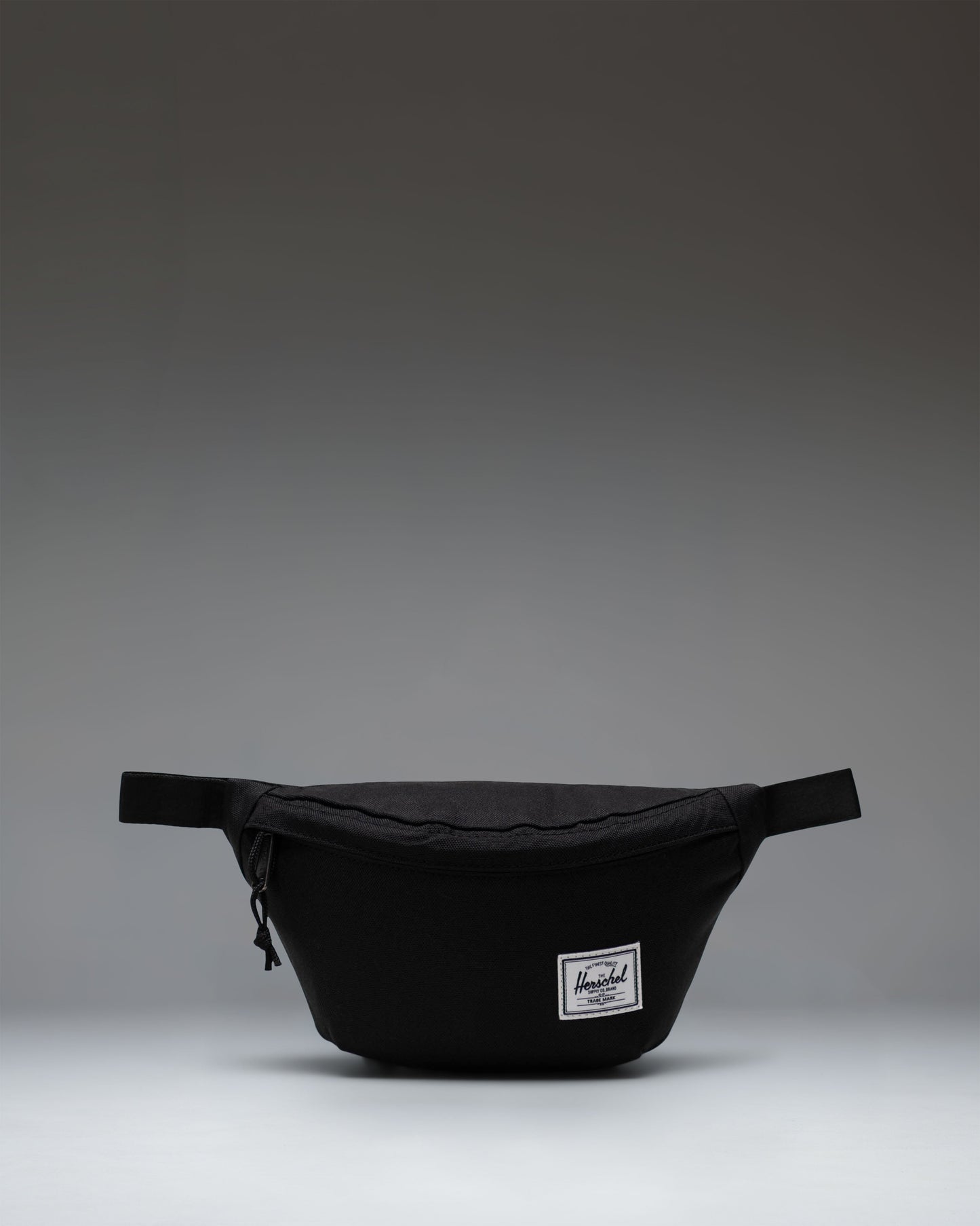 Black Herschel Classic Hip Pack featuring a main zippered compartment, front pocket, and adjustable webbed strap.