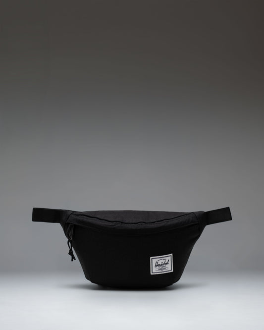 Black Herschel Classic Hip Pack featuring a main zippered compartment, front pocket, and adjustable webbed strap.