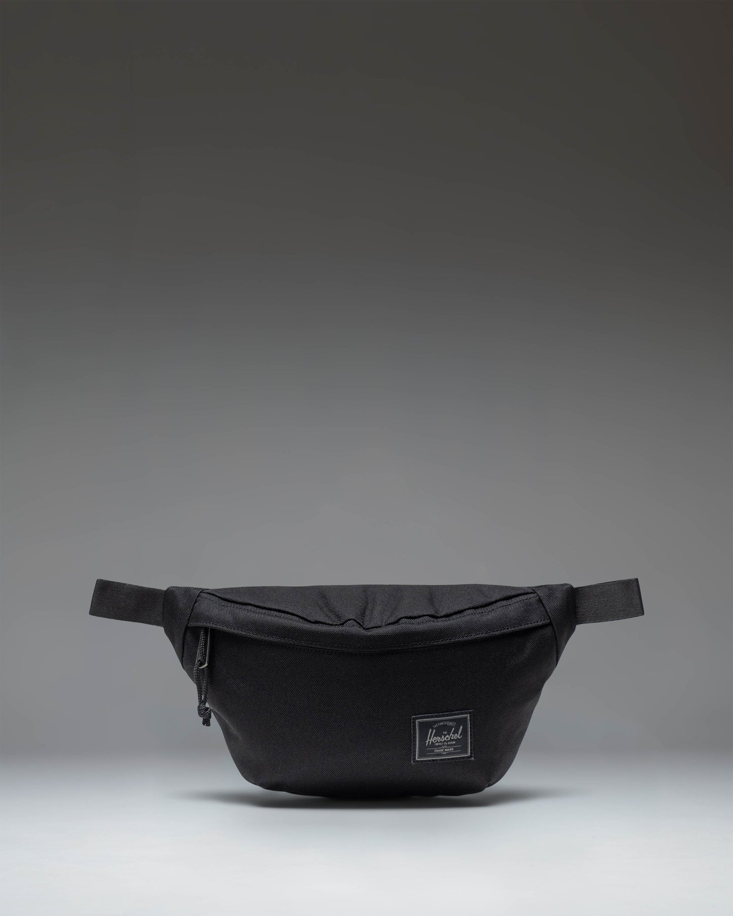 Herschel Classic Hip Pack in Black Tonal fabric, showing the front view with zipper closure and brand logo.
