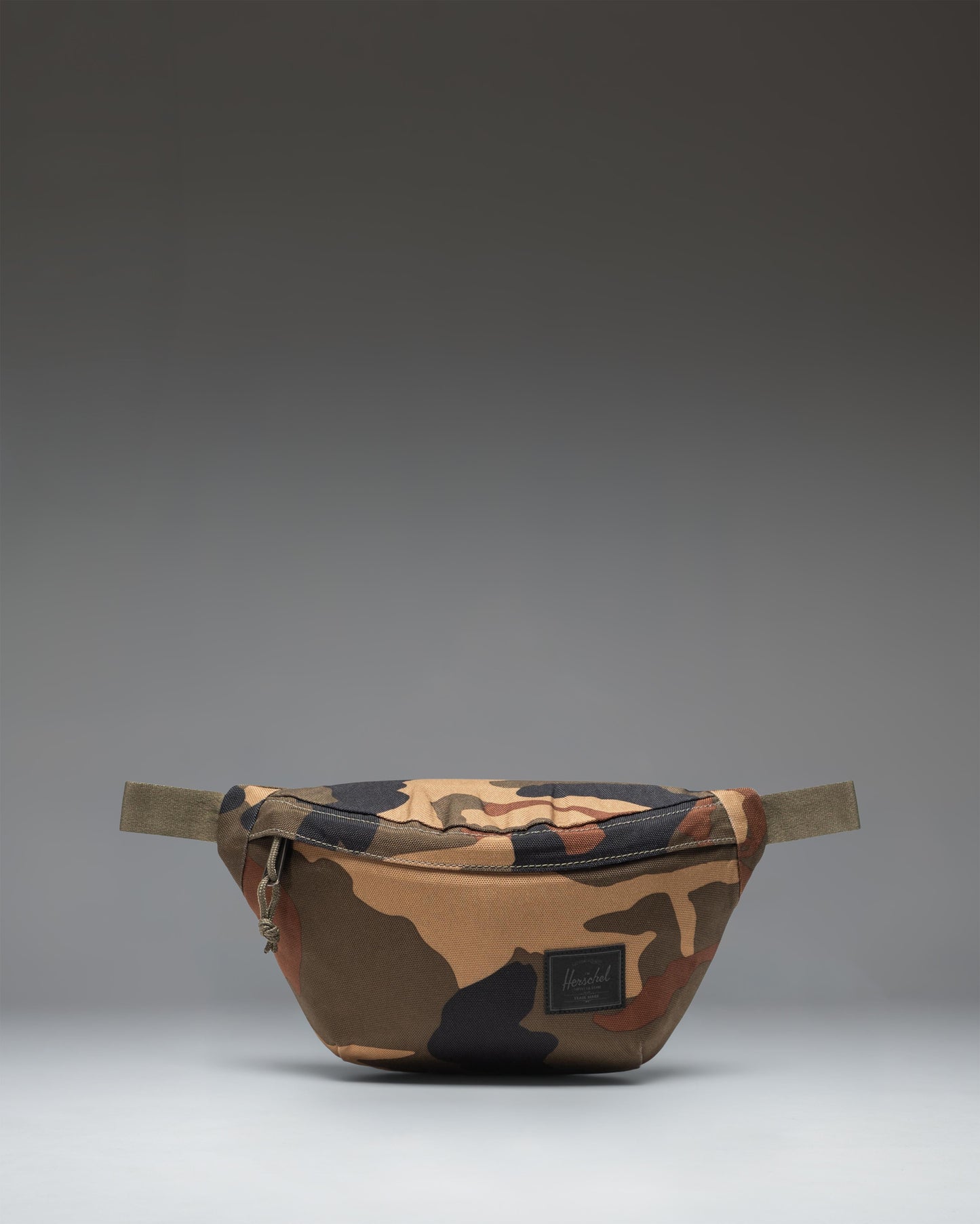 Herschel Classic Hip Pack in Woodland Camo with a black label, shown from the front against a white background.
