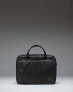 Herschel Supply Co. Gibson Messenger Tech bag in black, showing the front view with dual top handles, a removable shoulder strap, and front pockets.